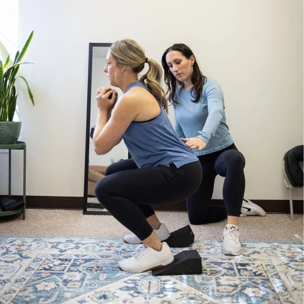 Dr. Zeno monitors a client's form + posture during an elevated squat in Mount Laurel, New Jersey. The exercise promotes pelvic floor healing + recovery by ensuring efficiency + effectiveness