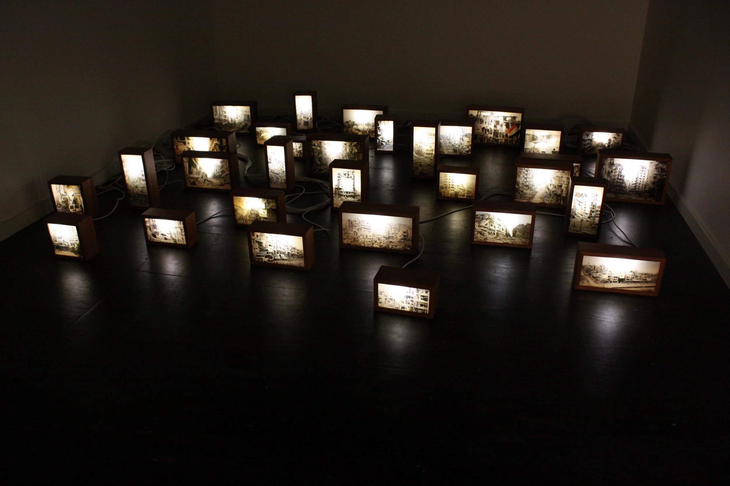 finding one’s shadow in ruins and rubble | 2014 | 31 hand-crafted mahogany wooden boxes, Reuters-licensed photographs, plexiglass, LED lights | dimensions of light boxes variable