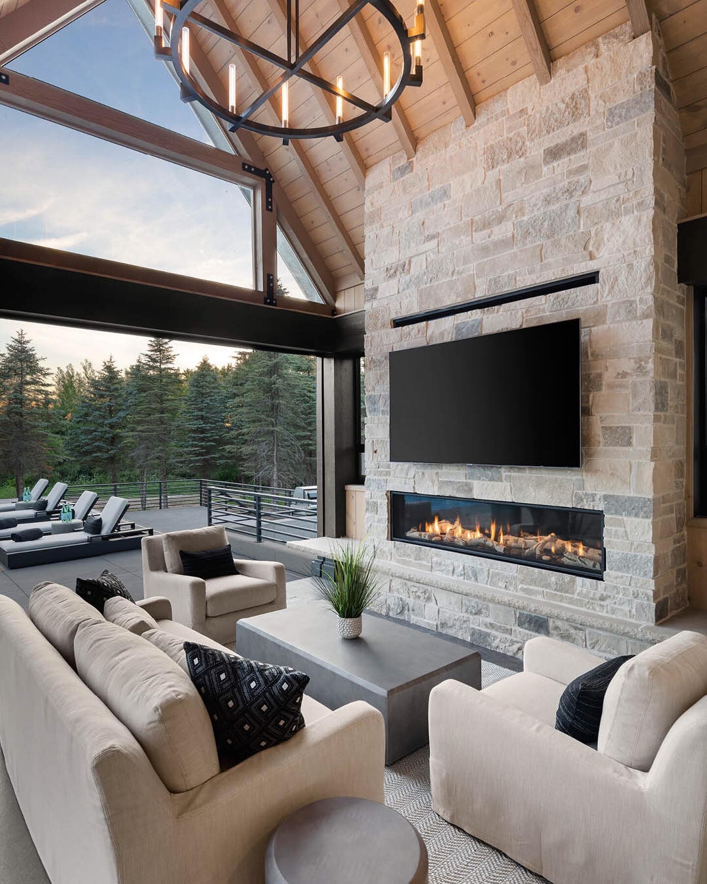 This indoor-outdoor space adapts perfectly to the unpredictable weather in spring, complete with a fireplace and retractable doors. Home by: @hartmanhomesinc 
#indooroutdoor #indooroutdoorliving #fireplacedesign #fireplaces #fireplacesurround #living