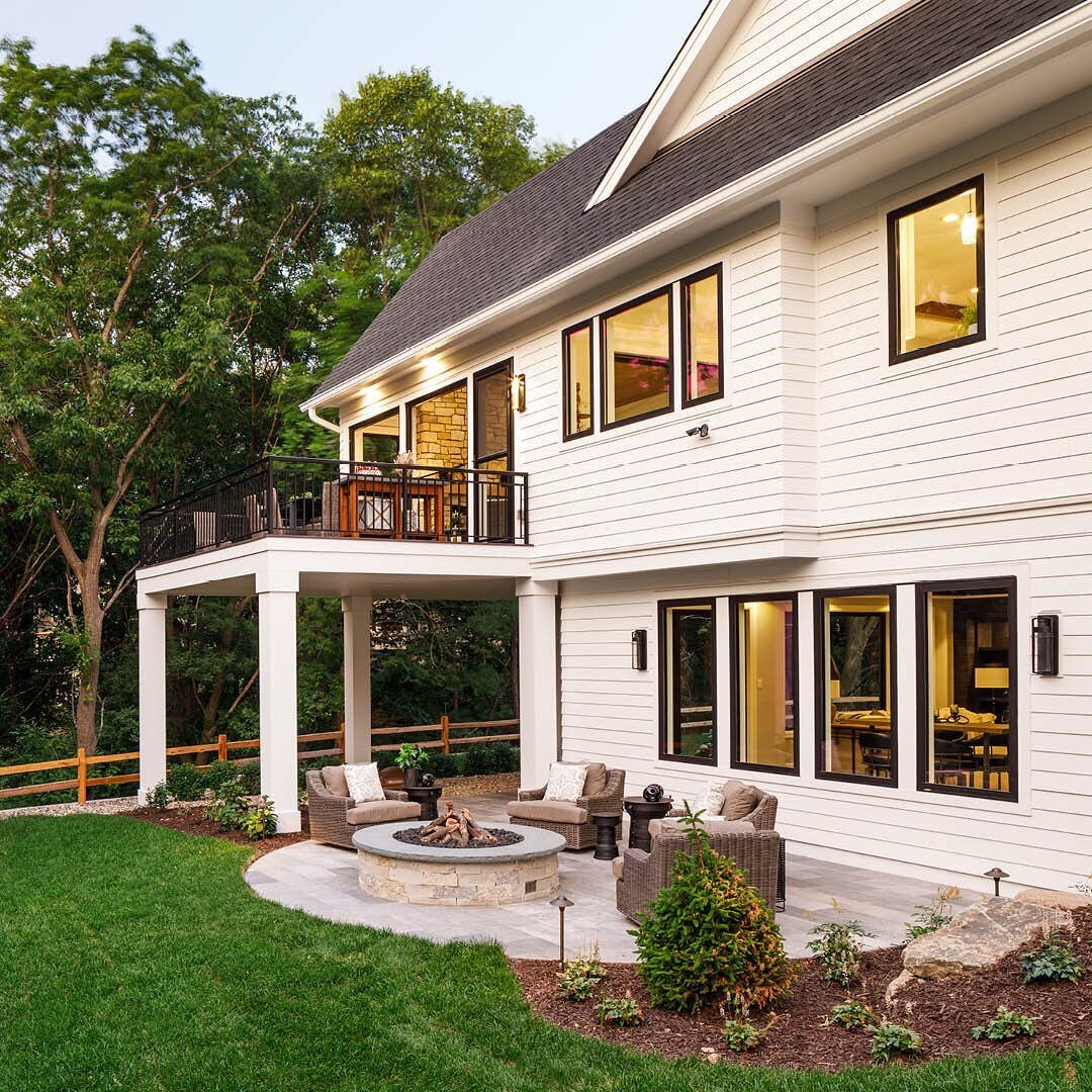 This home&rsquo;s backyard features gorgeous spaces to soak in the season, from the patio firepit to the spacious deck. Swipe to see a view of the front of the home. @wooddalebuilders 

#backyardoasis #deckdesign #patiodesign #whitehouses #firepit #h