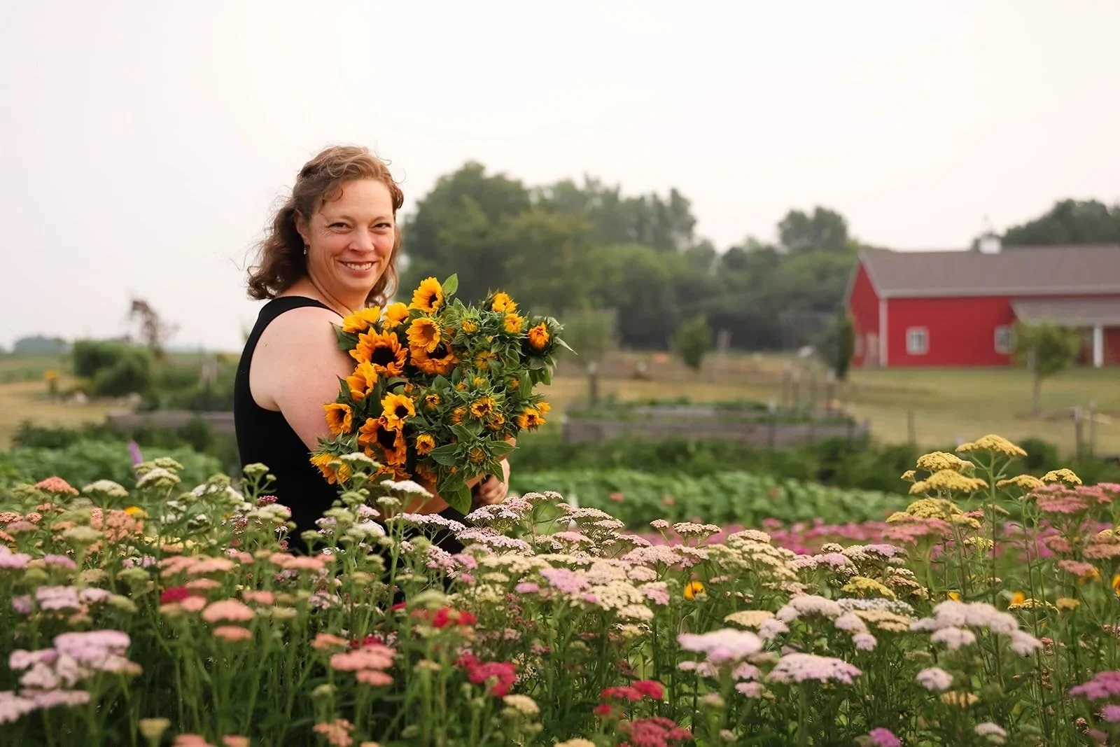 flower-farming-for-profit - woman holding a bunch of sunflowers