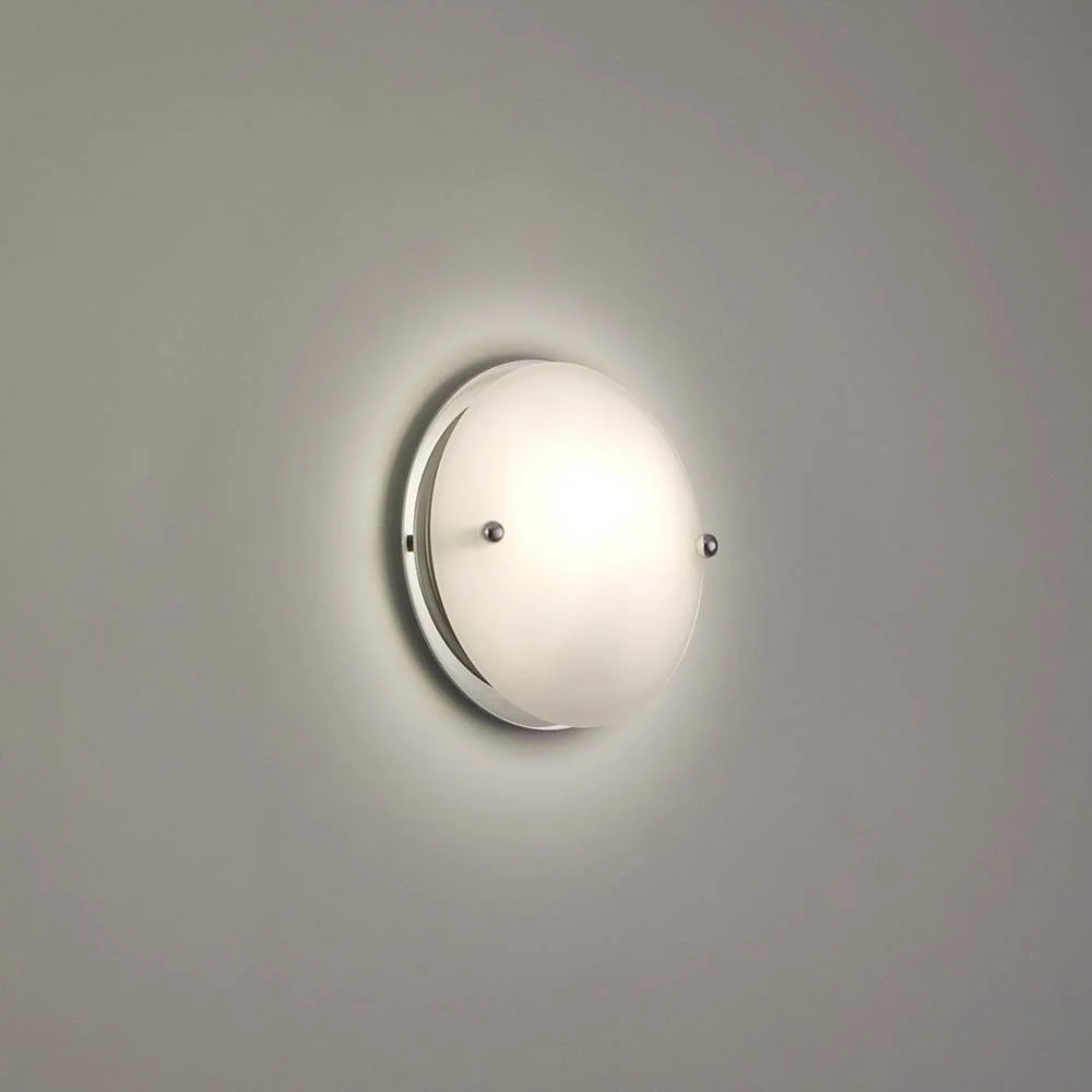 round illuminated light fixture on the wall with two polished chrome connector nuts