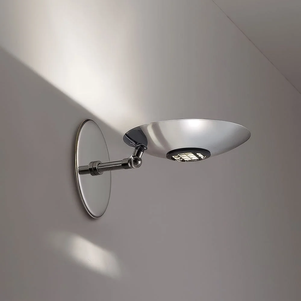 a polished chrome up & down light illuminated round dish sconce with a short stem and a round mounting plate with no screws visible