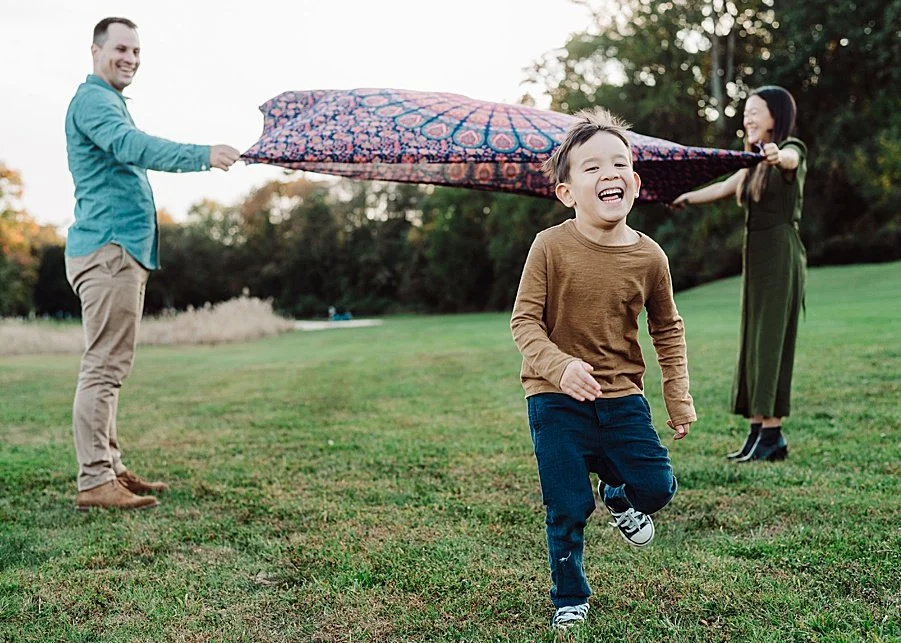 Parents and a son smiling at a park 