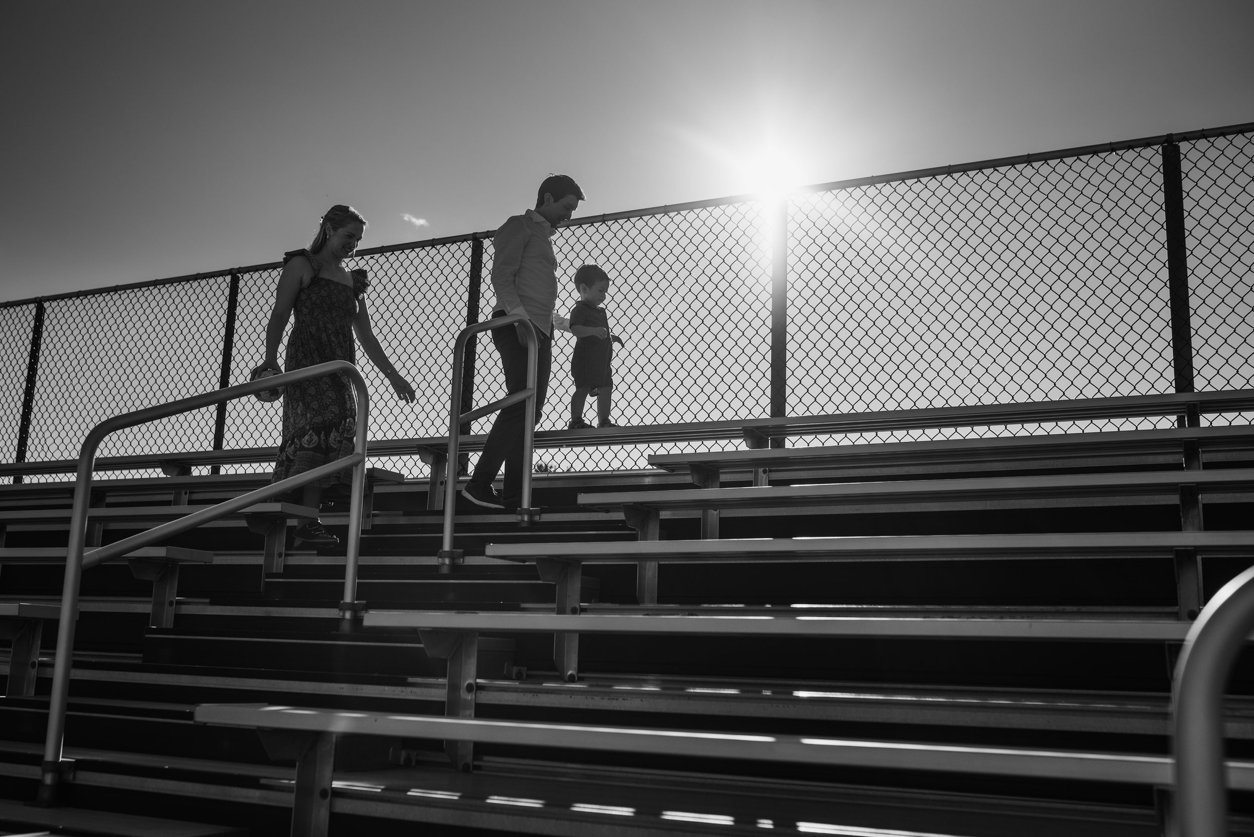 A family of three in backlight sunset light 