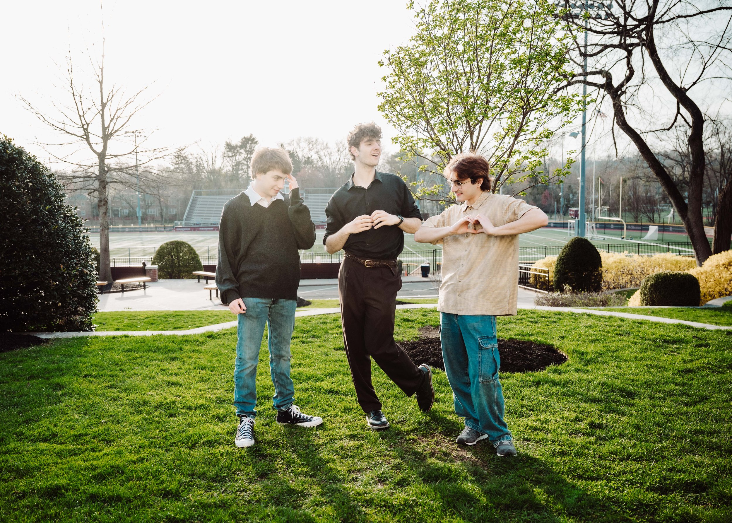 Three boys on the lawns of high school talking to each other