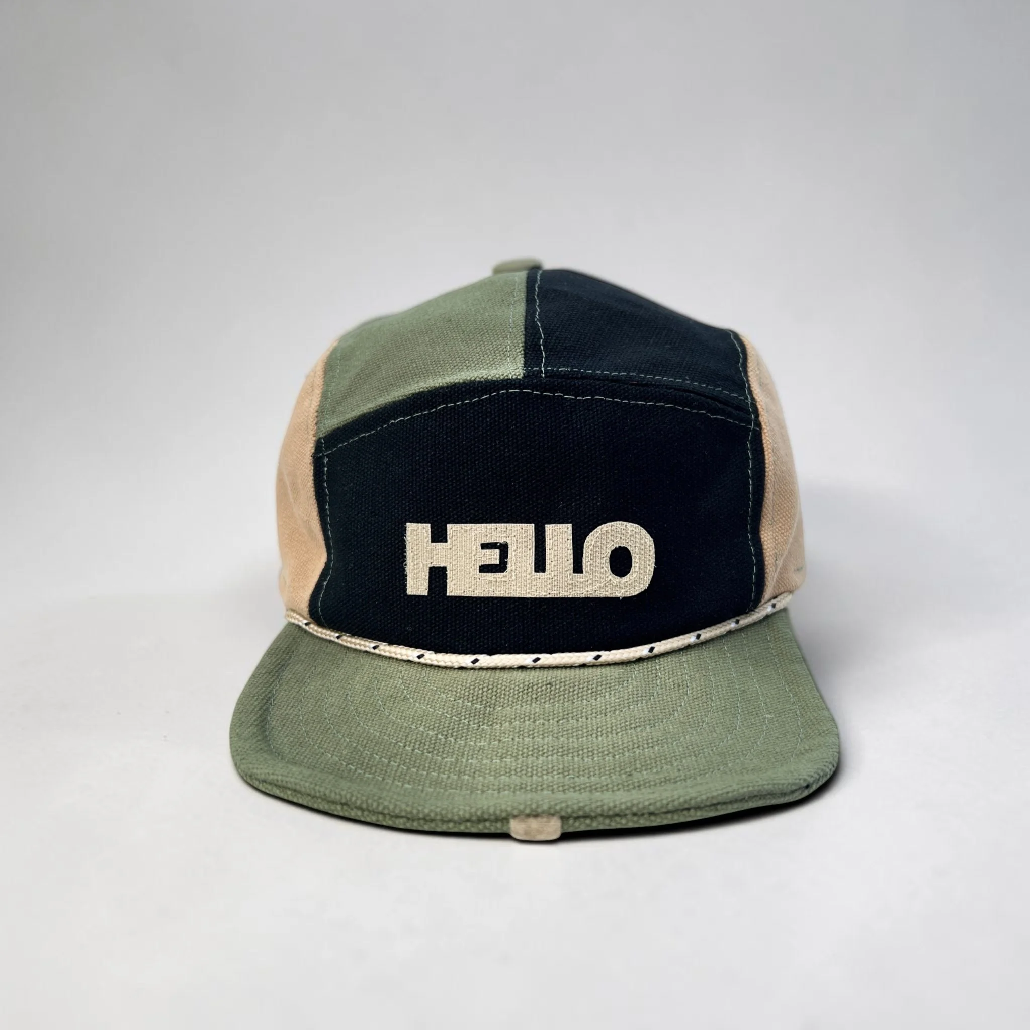 Olive, beige and black 5-panel baseball cap with beige HELLO velcro motif and olive roll-up visor.