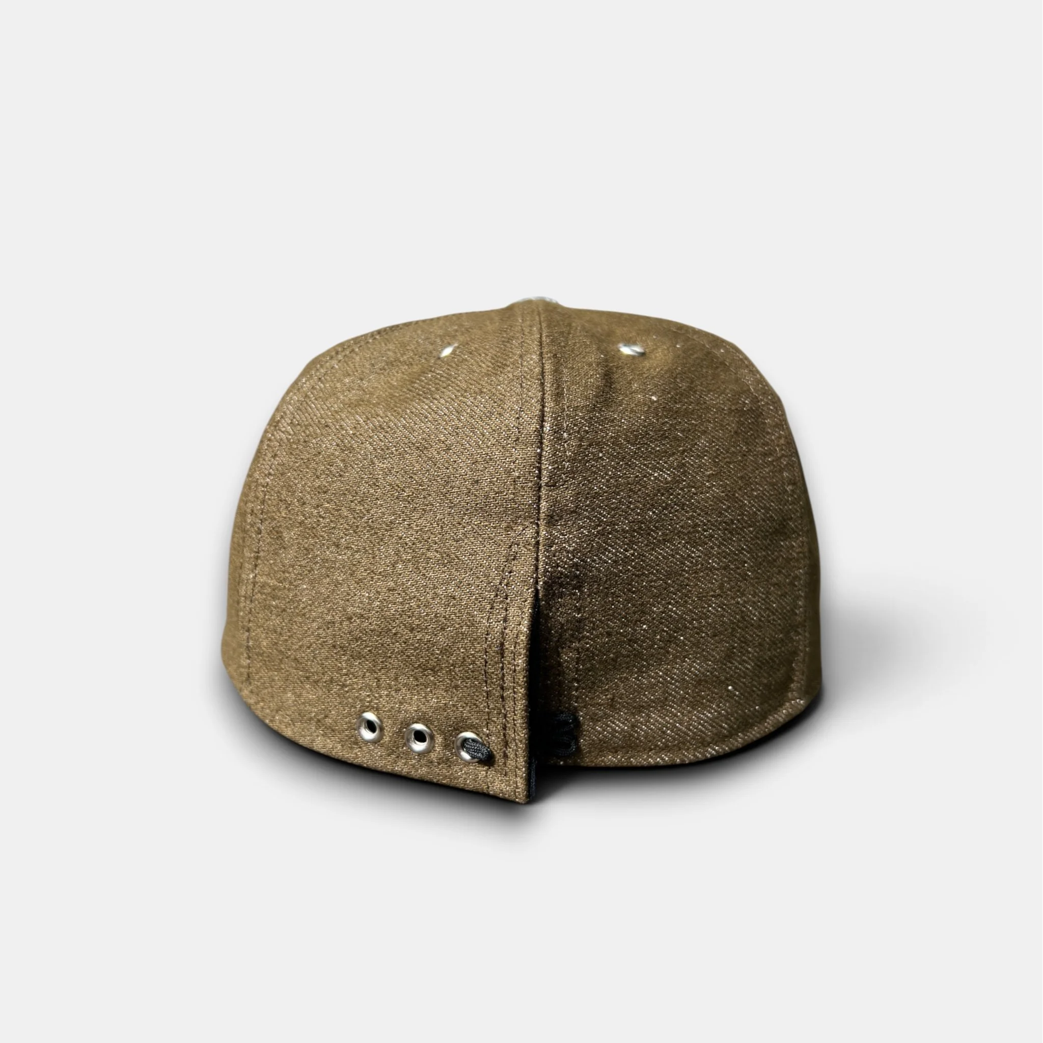 Rear view of olive-brown cotton denim eight-panel cap showing metal eyelets and adjustable closure