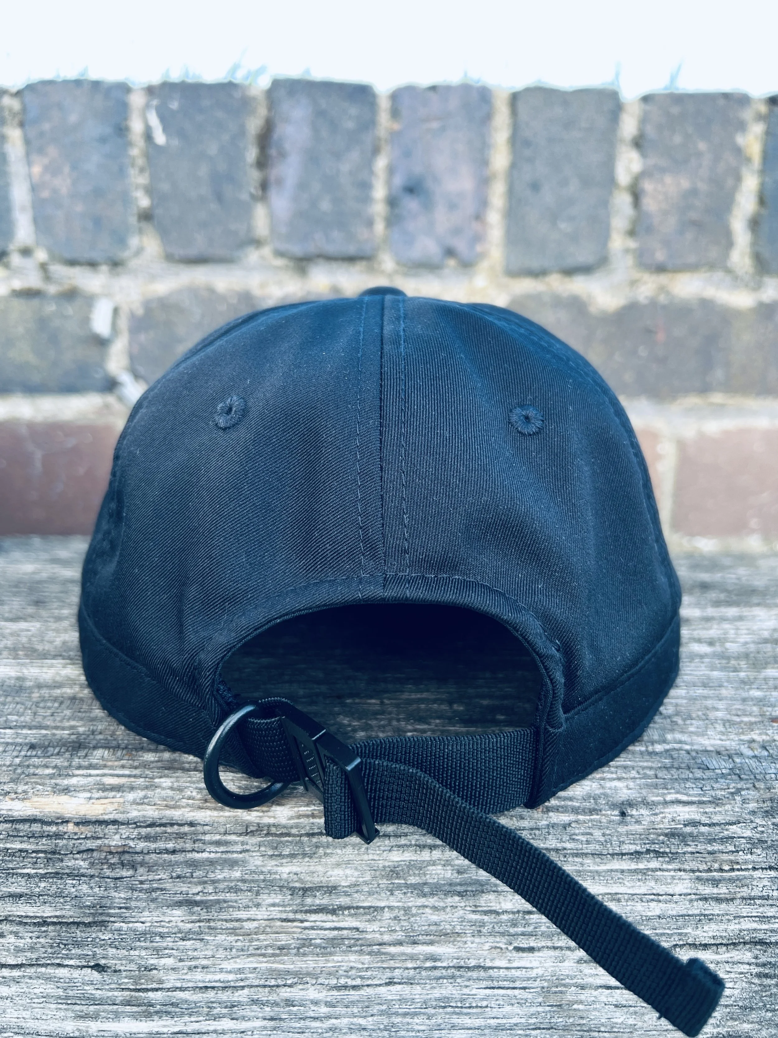 Navy view of navy six-panel cap showing adjustable strap, D-ring loop and lightweight buckle