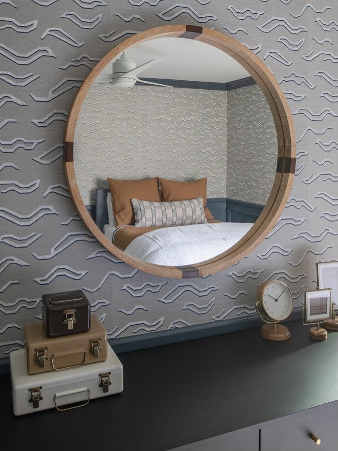 We maximized the floor plan design in order to create all the crucial spaces on the must-haves list for this boys bedroom project (sleep, study, play). Wrapped in hand block painted grasscloth and pattern-on-pattern window treatments for a whimsical 