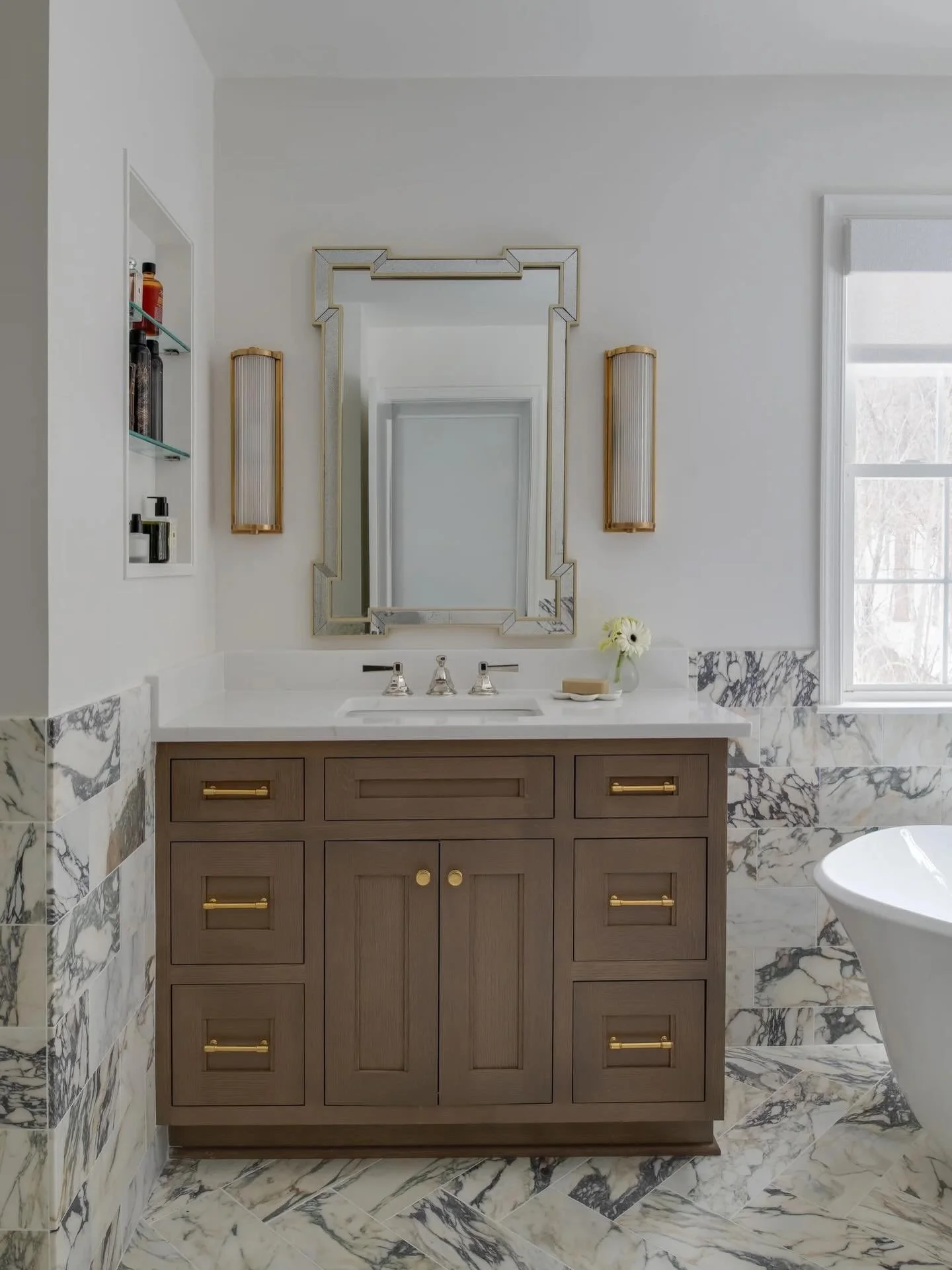 Wintry whites and the woods outside made it the perfect time of year to shoot this bathroom remodel. Elevated this space with inset white oak cabinetry, an etched glass medicine cabinet on one side, and custom niche with open shelving on the other. 
