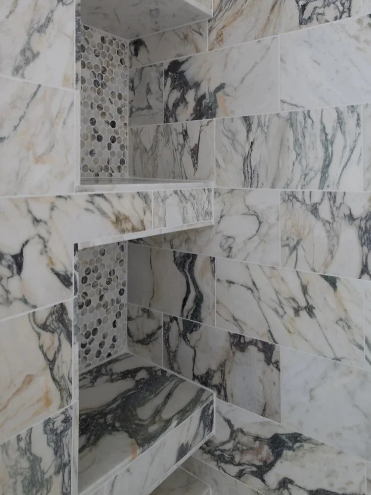 On the wish list for this bathroom renovation was an expanded shower footprint. We used space from an adjacent closet to increase the size of this shower, now a steam shower, and gave our clients ample storage for products in the niches tucked away t