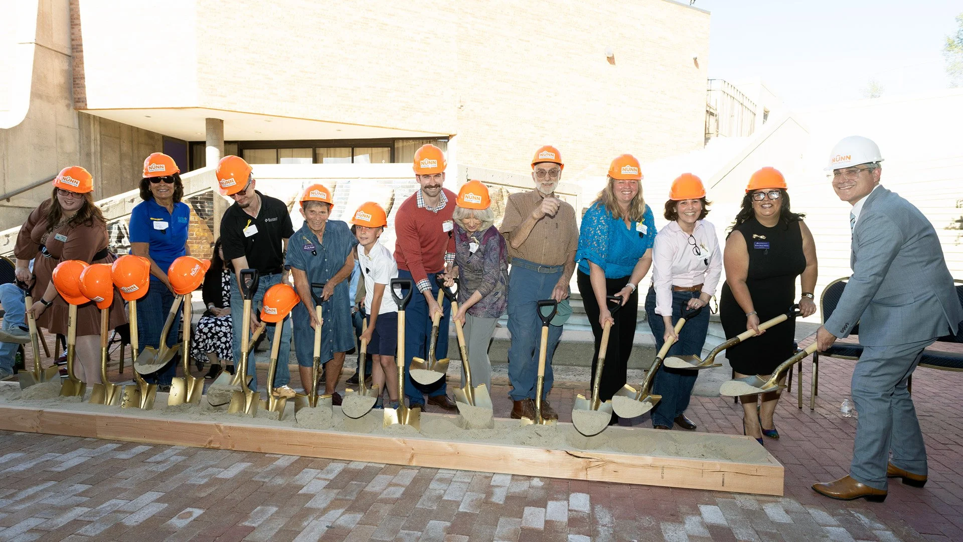 Image of individuals in hardhats with shovels