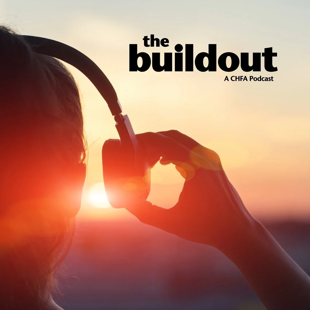Closeup of the back of a persons head with headphones on looking at a sunset and The Buildout Logo in the upper right