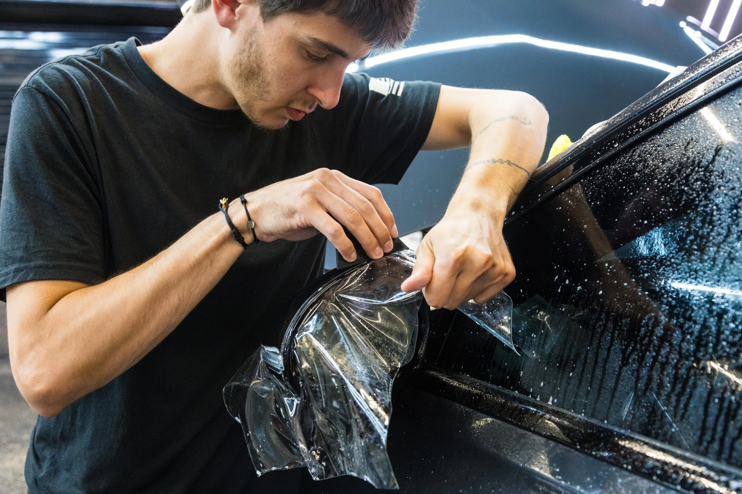 Black BMW receiving a paint protection film (PPF) application by the Evolution Auto Spa team in Sea Girt, NJ.