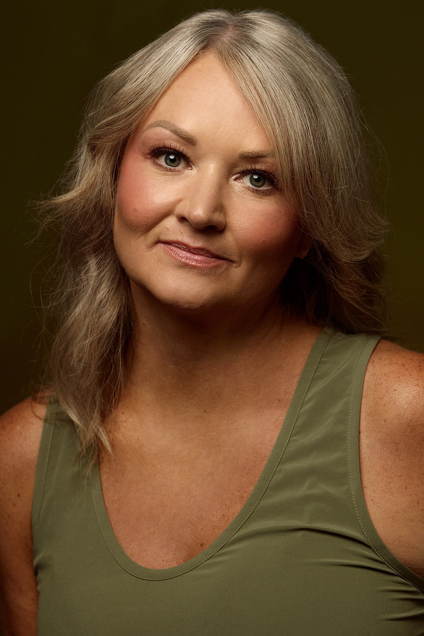 Over 50 beauty model with flawless natural skin and grey hair looking directly at the camera, photographed in Toronto for her beauty model portfolio.