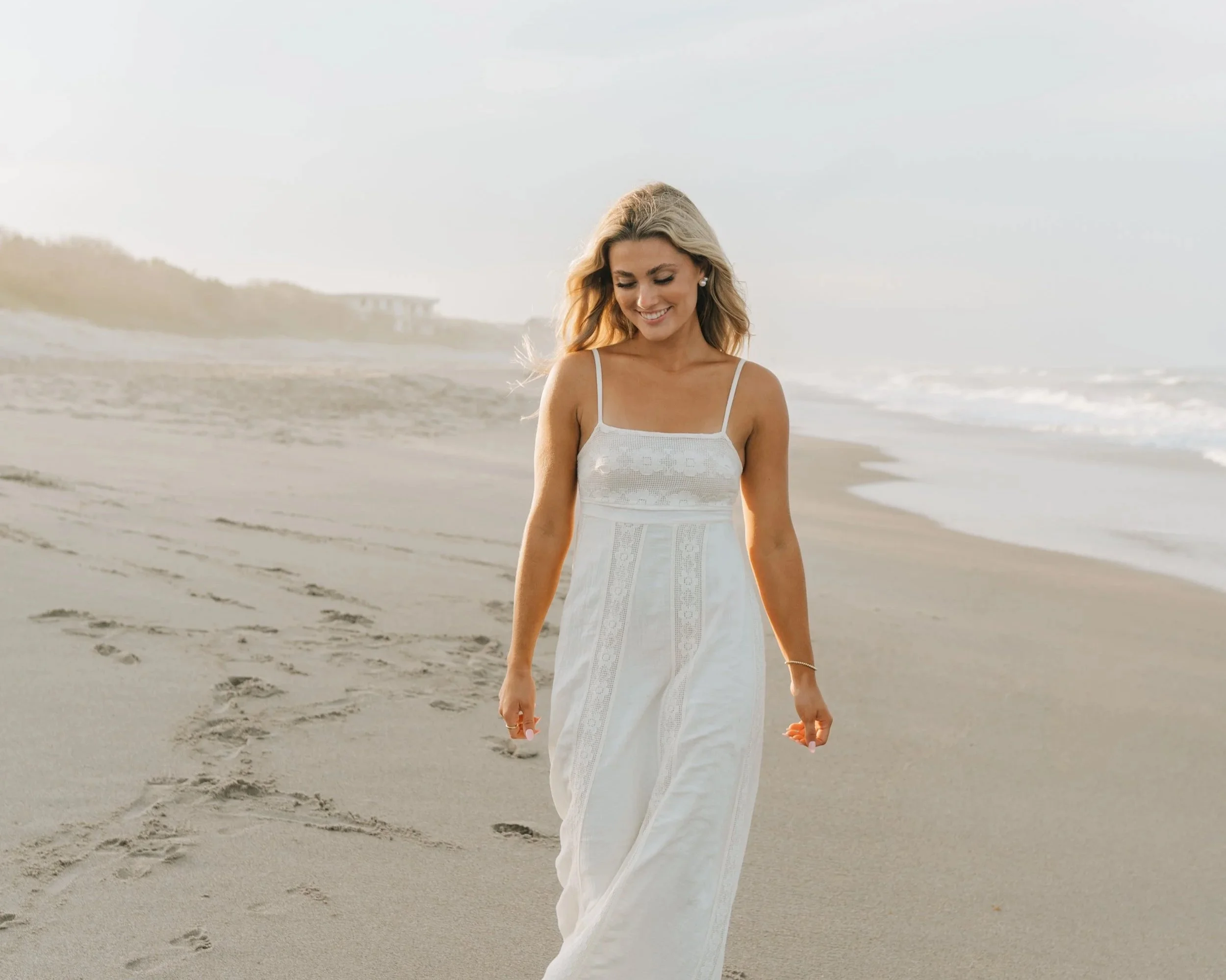 High school senior walking along the beach during her senior photo session in Melbourne Beach, Florida.