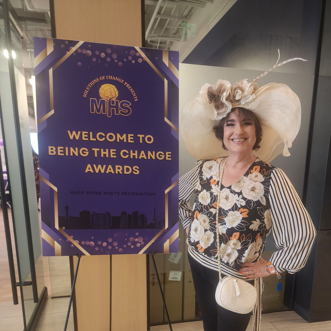 Ruth Furman next to a solutions of change MHS Beign the Change Awards sign