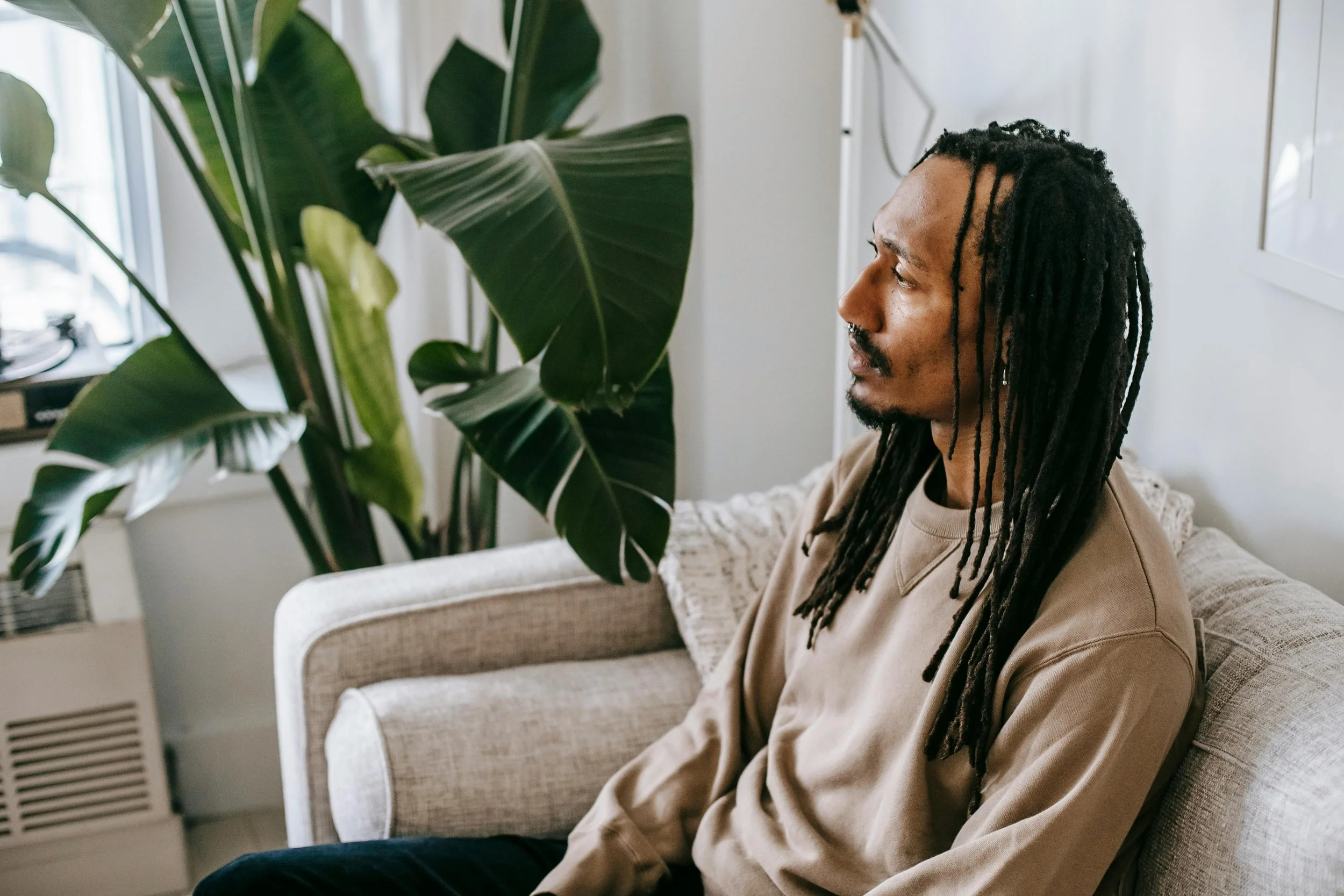 Man thinking about CBT therapy for intrusive thoughts in therapist office, Brookline, MA.