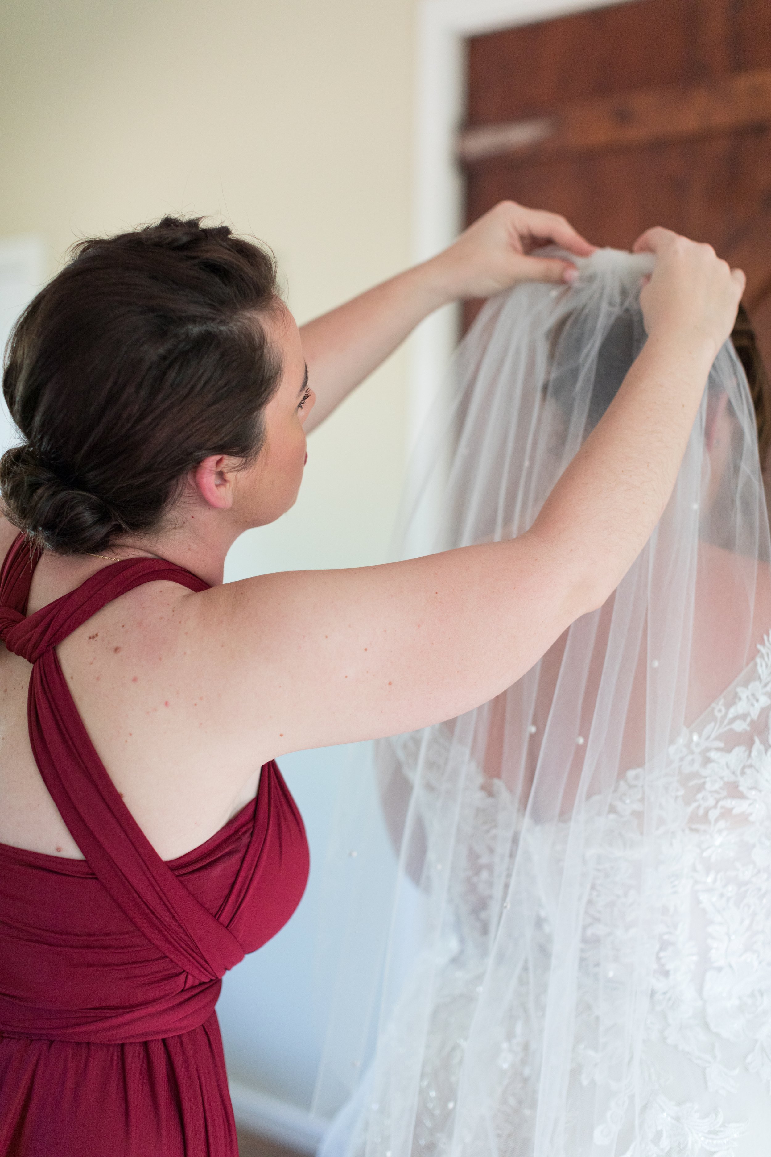 bridesmaid helping with the veil at Nukara Farm wedding photography.jpg