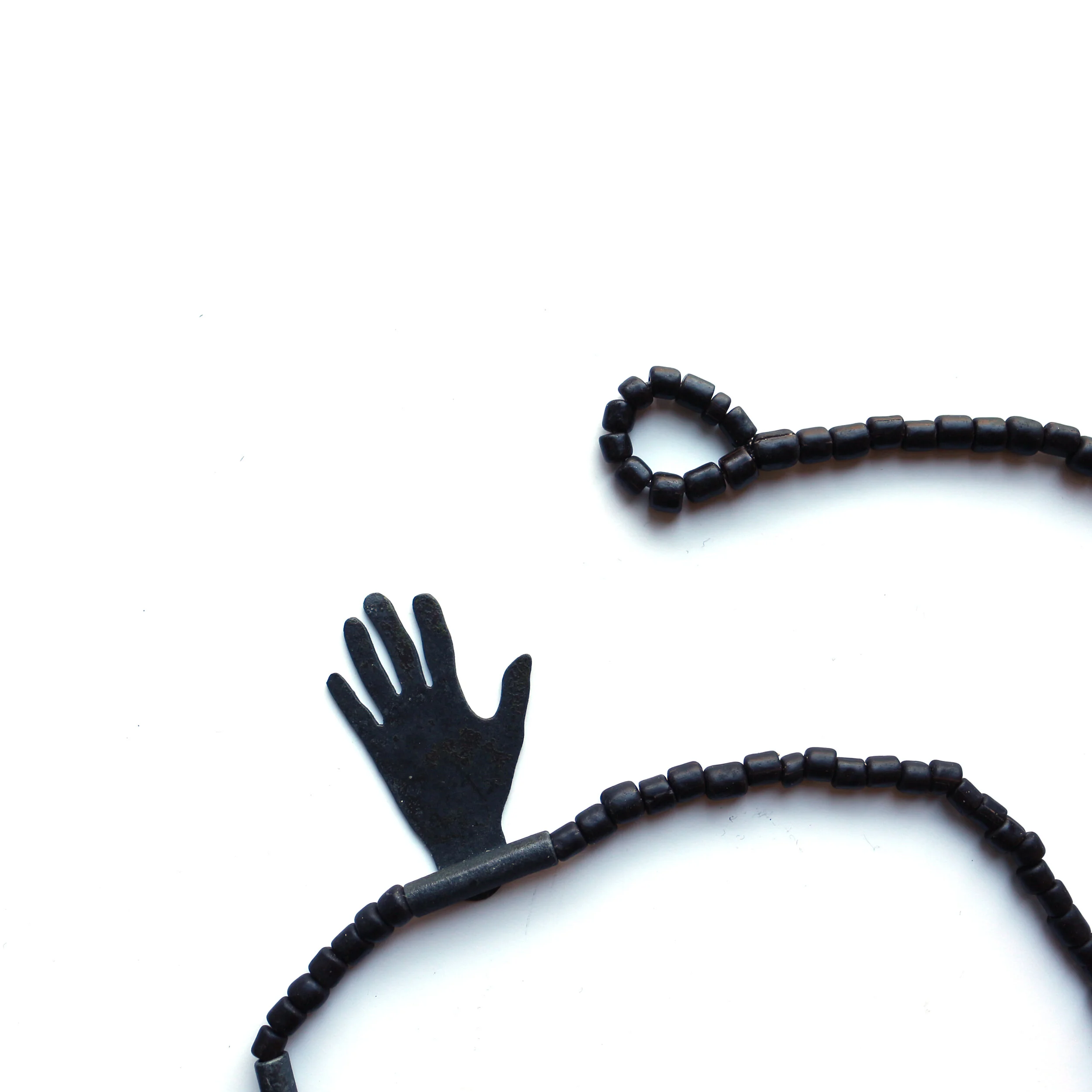 Hug II. /detail/ - Materials: zinc, glass beads, nylon cord
