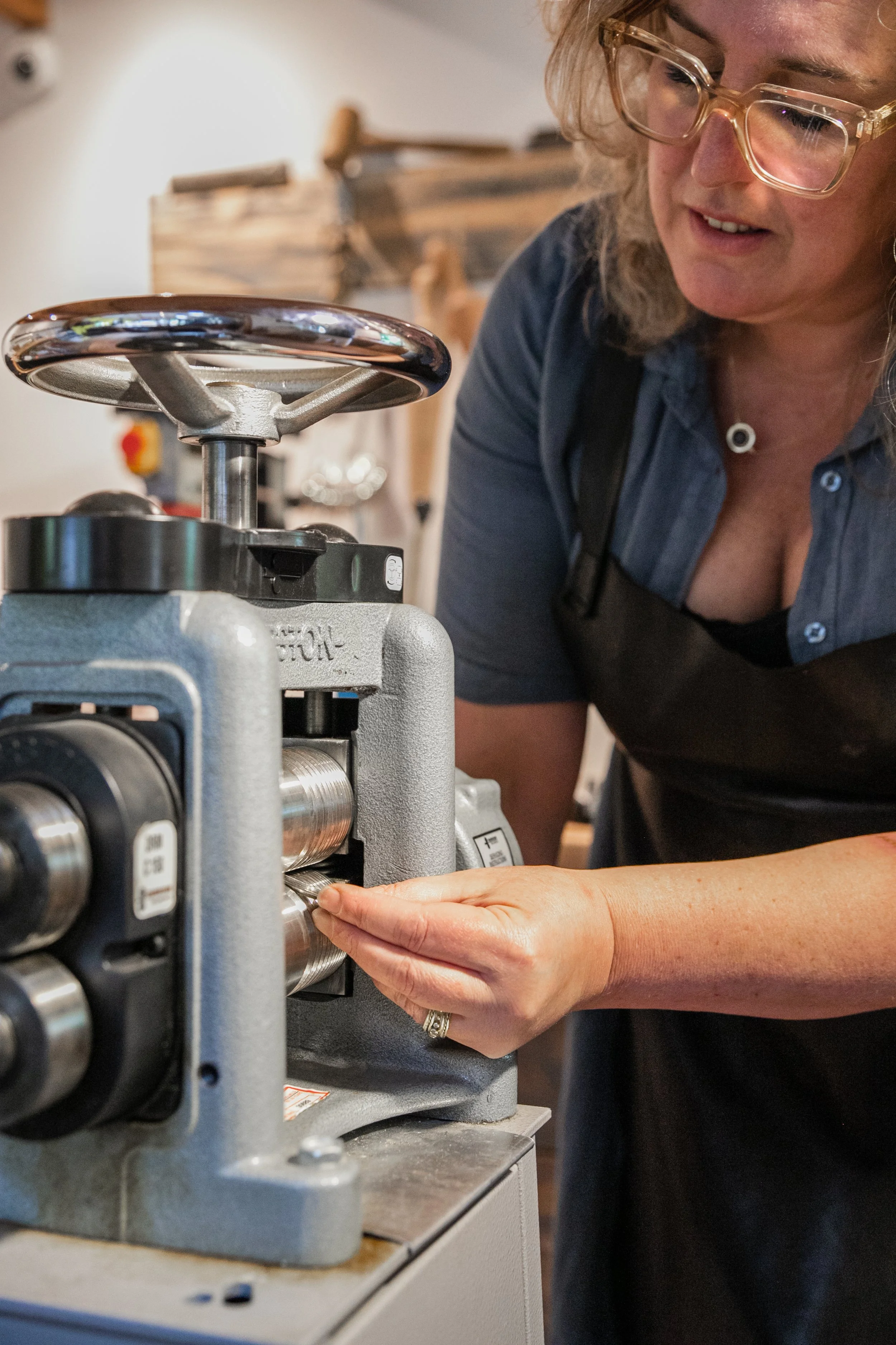 Goudsmid Margriet tijdens het walsen van goud