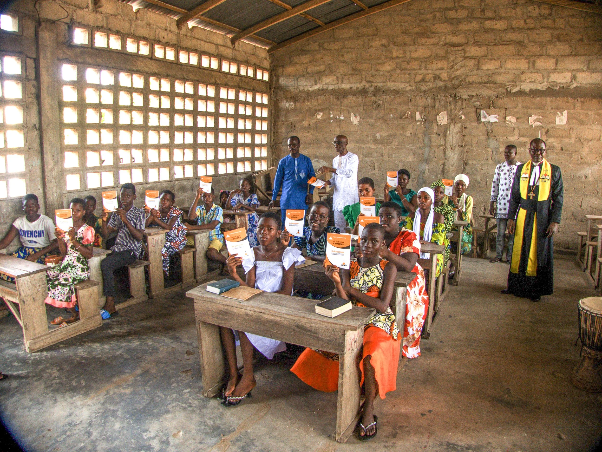 Children in rural societies receiving their Catechism booklet.jpg