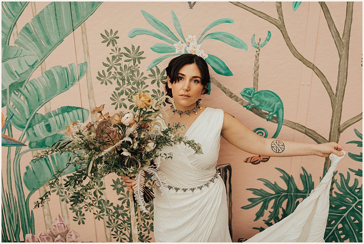 Bride on wedding day in front of pink floral wall | Lauren Parr Photography