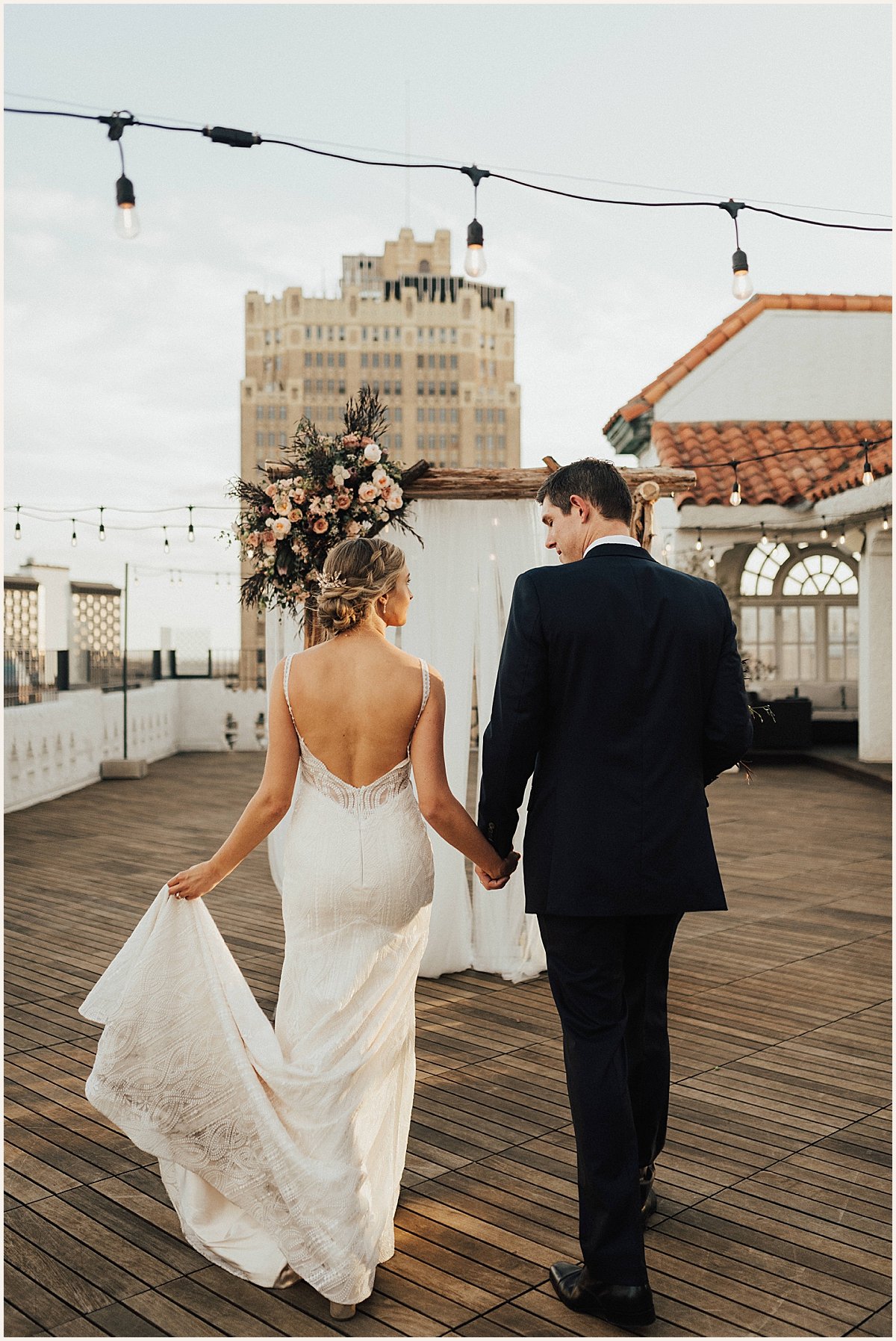 Bride and groom walking into sunset after rooftop wedding | Lauren Parr Photo