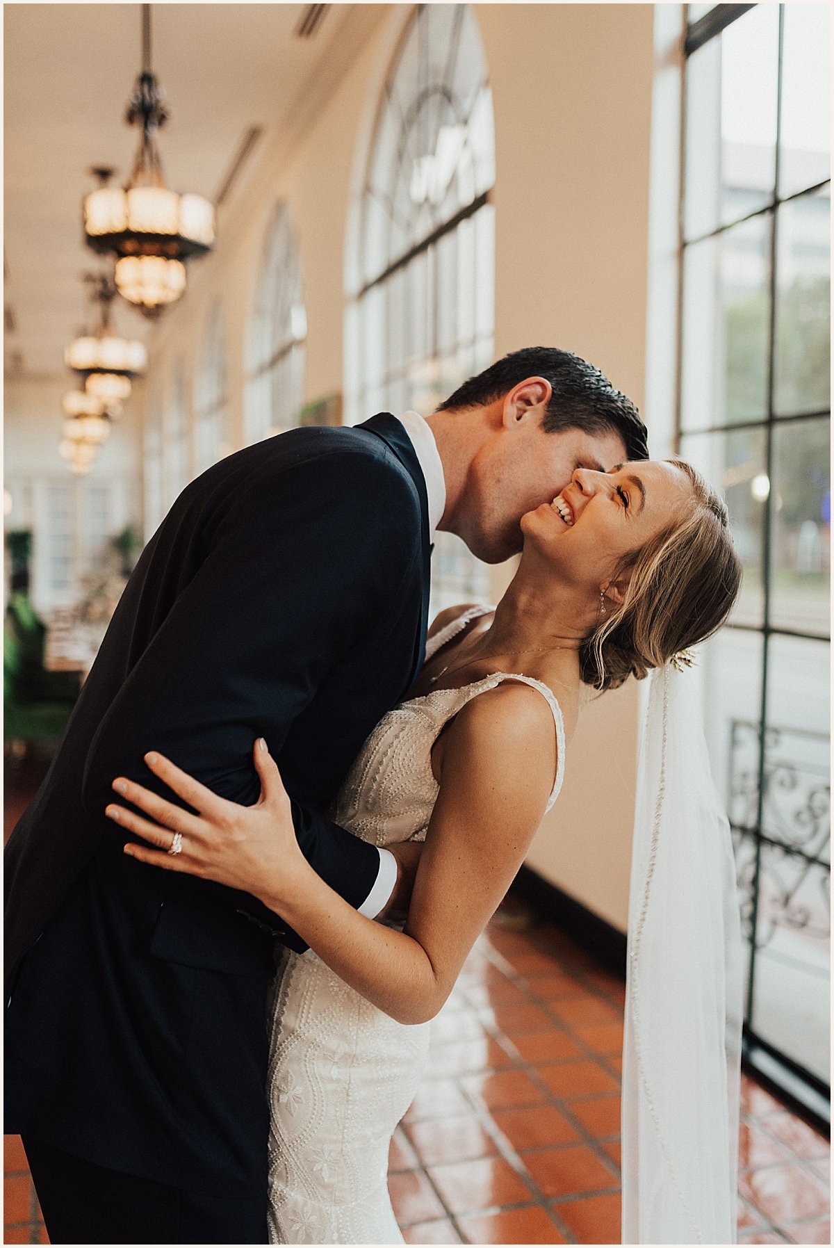 Bride laughing while groom kisses neck on wedding day | Lauren Parr Photo