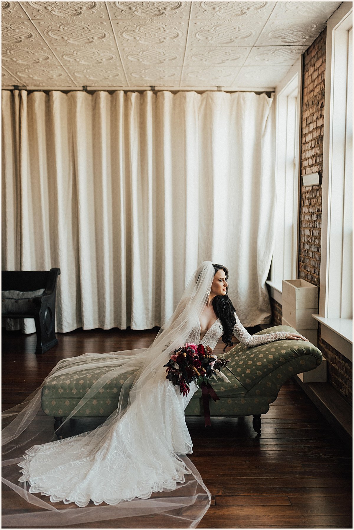 Bride sitting on couch looking out window | Lauren Parr Photography