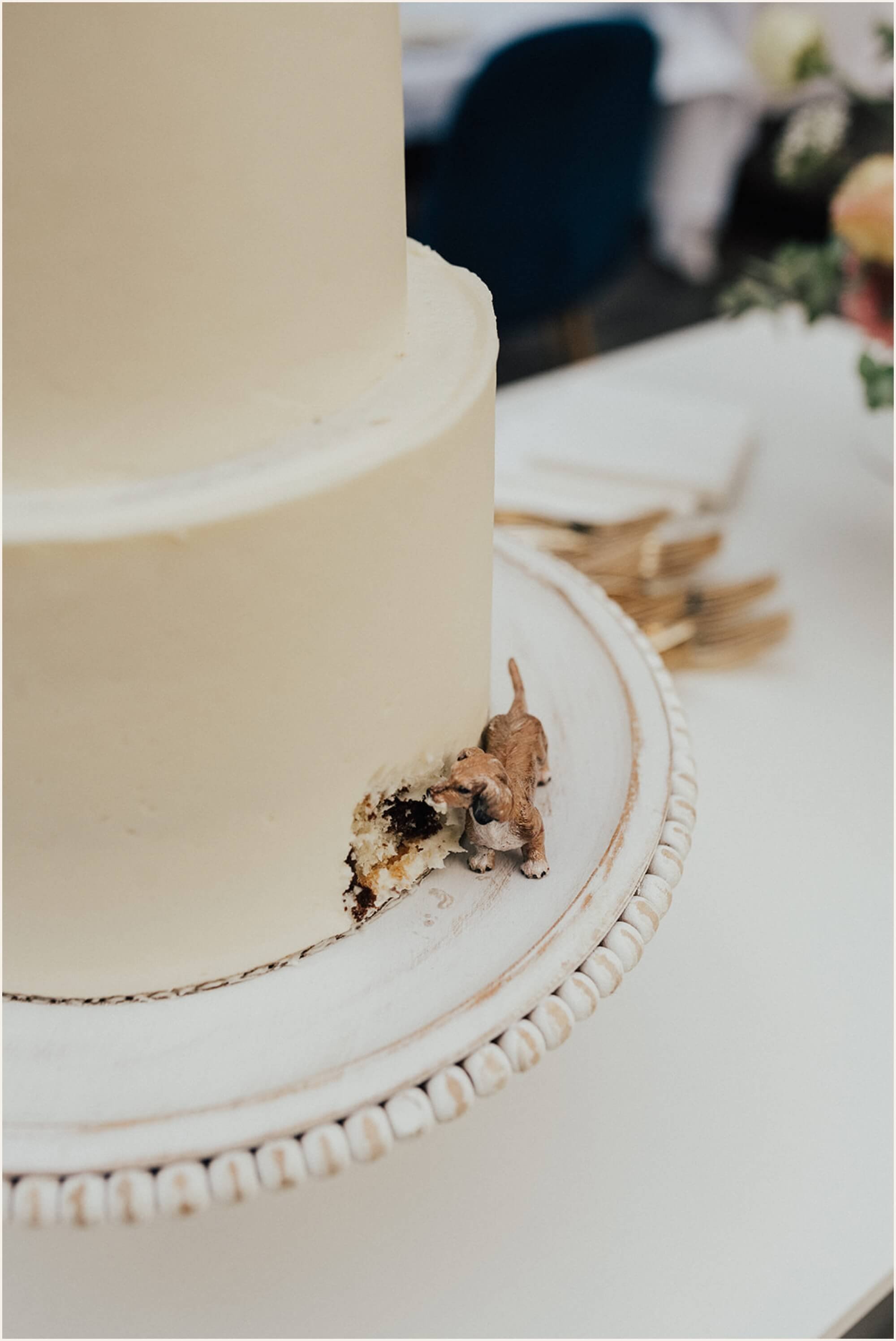 Dog taking bite out of wedding cake