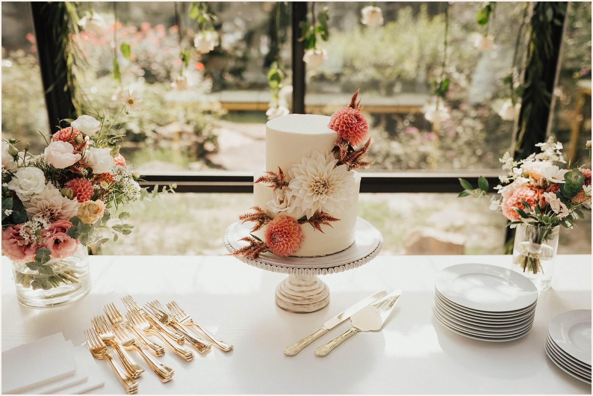 Two tier white wedding cake with dahlias