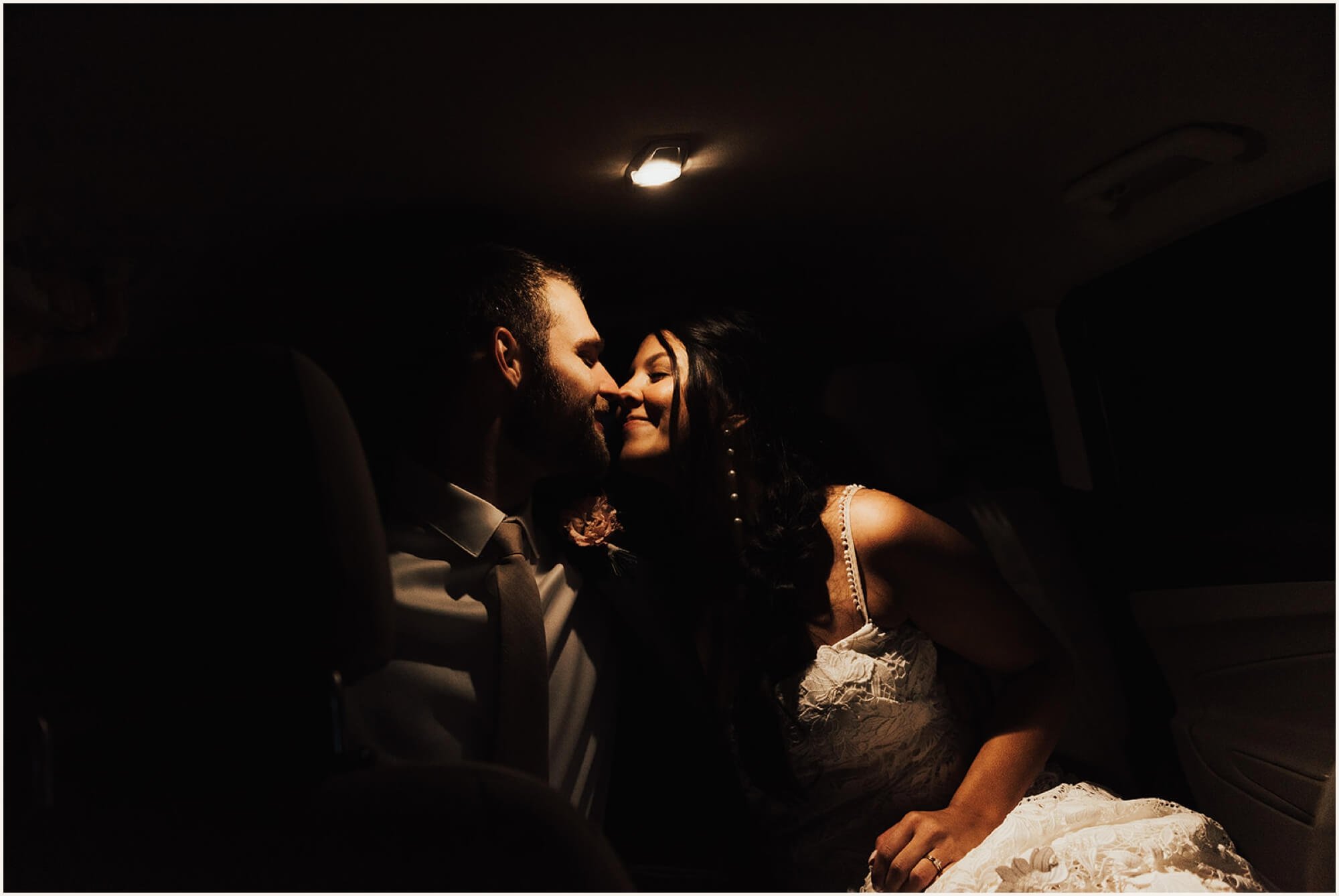 Bride and groom kissing in the car