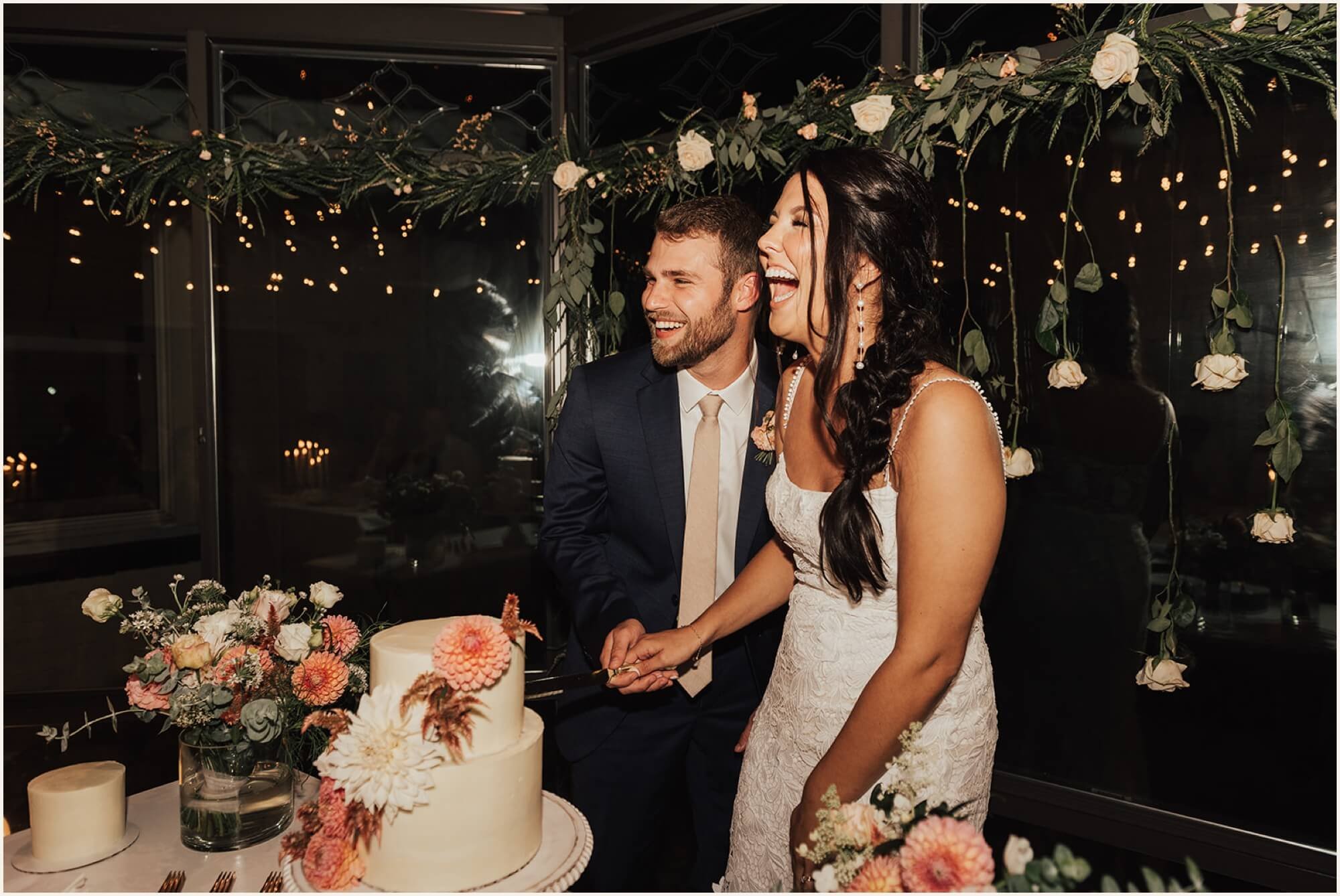 Bride and groom laughing during cake cutting