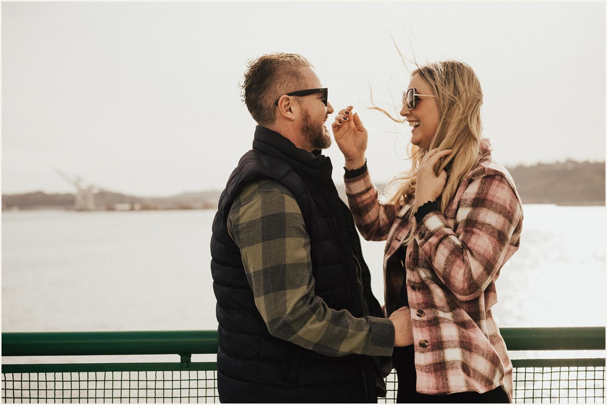 Couple standing on the deck of ferry and looking at each other during engagement photos
