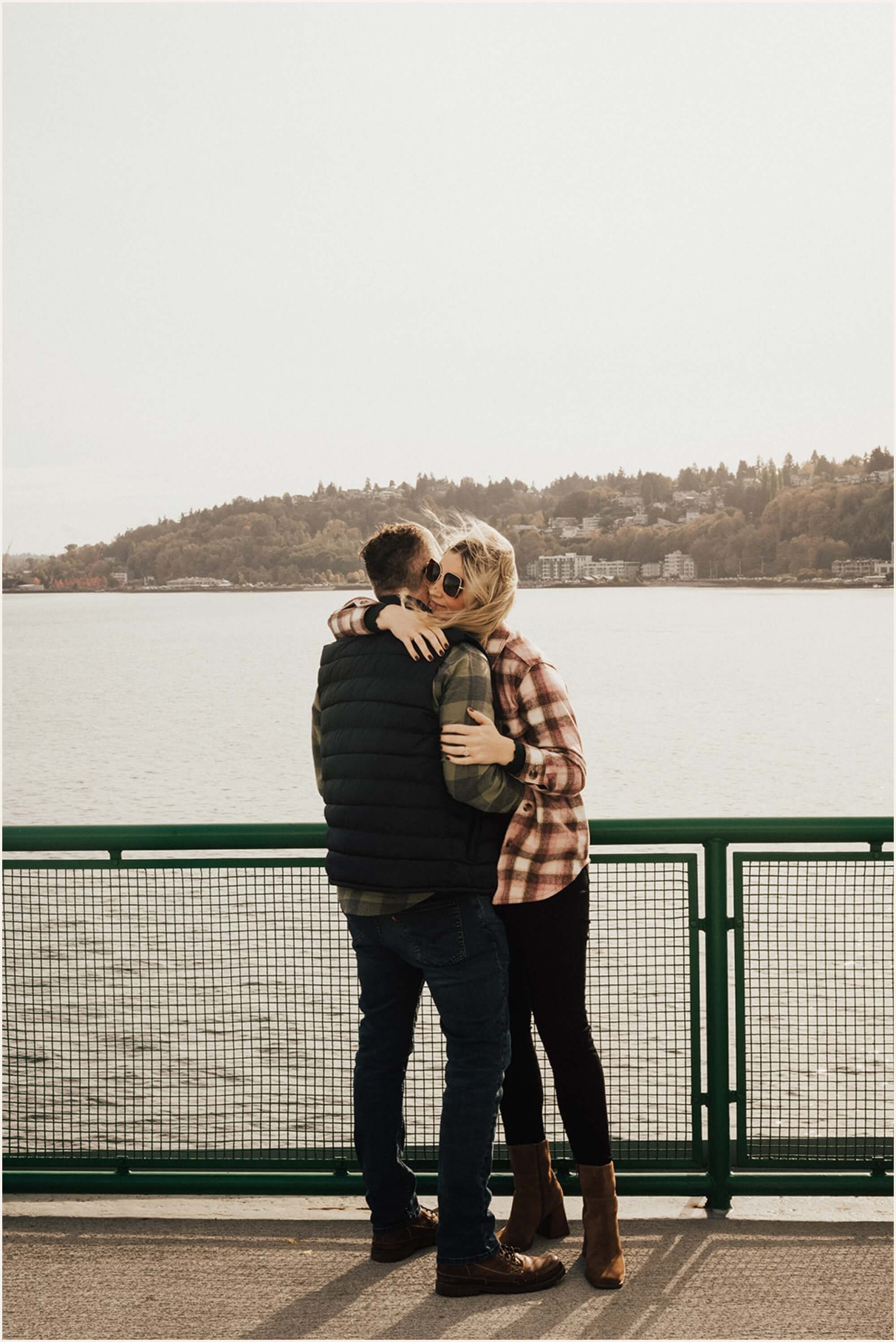 Couple hugging on ferry deck during Seattle engagement photos