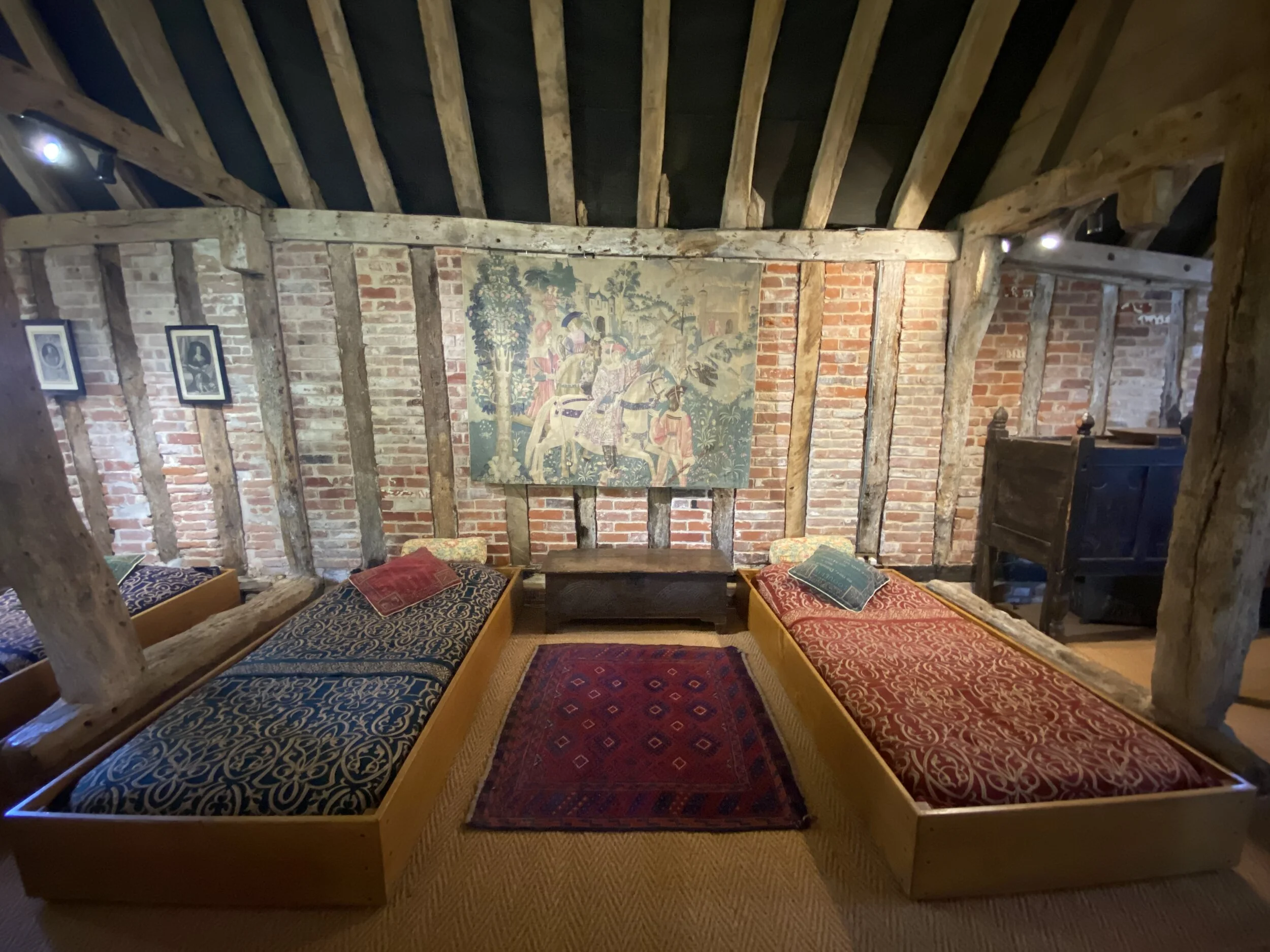 Six single comfy Tudor box beds down the sides of the barn