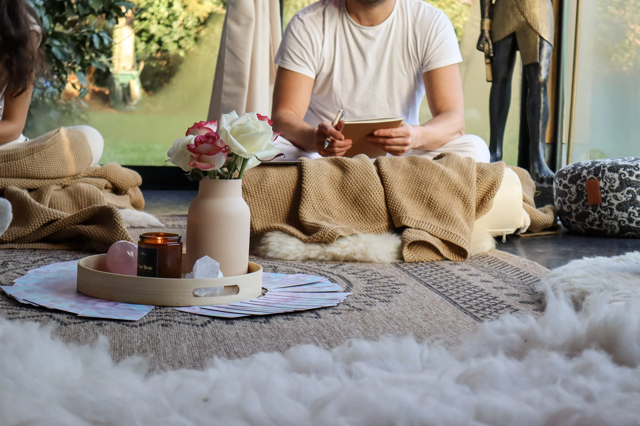 Sfeerbeeld met kaarten, bloemen en kaarsen tijdens een energetische groepssessie van Melissa Cuyt
