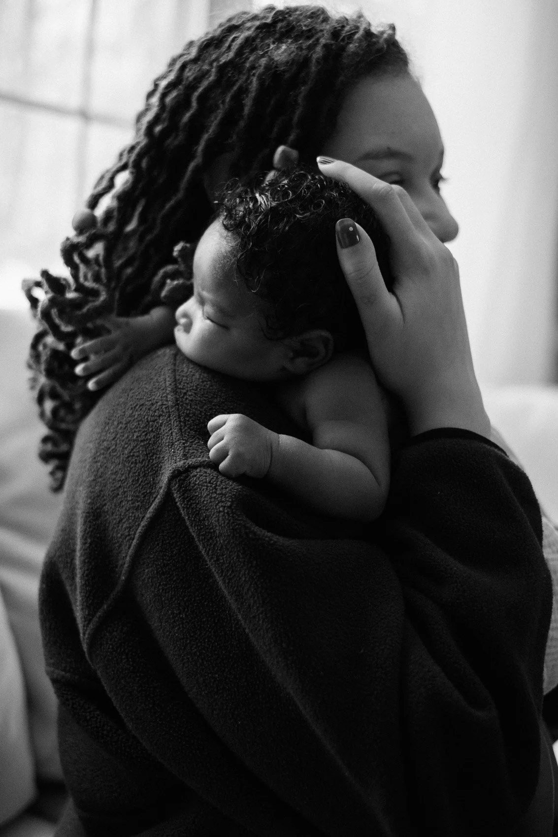 sleeping baby snuggled up to mom resting on her shoulder
