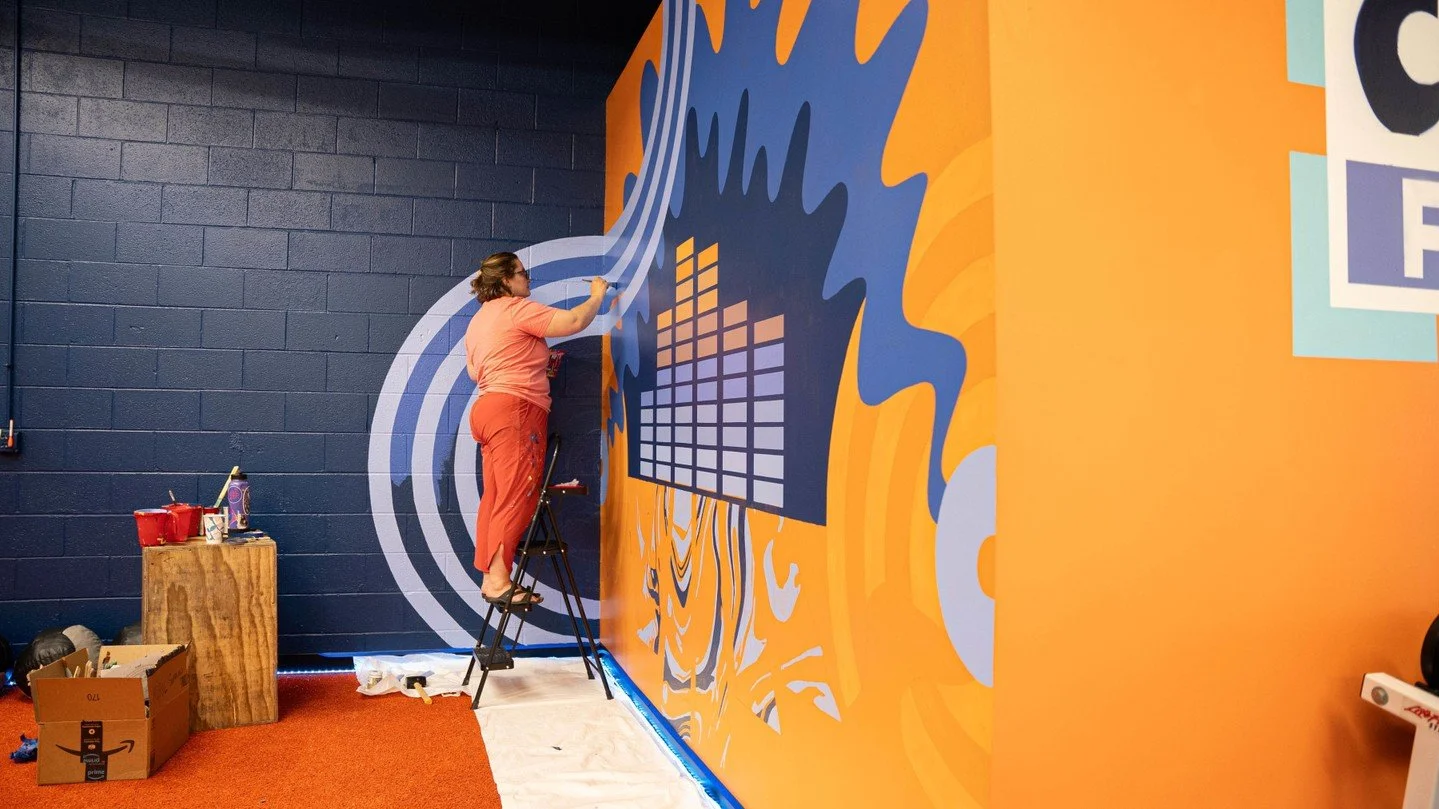 @capturefitindy and @sienabaldi teamed up to co-create a mural that tells the story of Capture Fitness through mind-bending, musically-inspired imagery. 
A dash of 90s Nickelodeon, sensual paint swirls, and a skyline of stacked weights/sound visuali