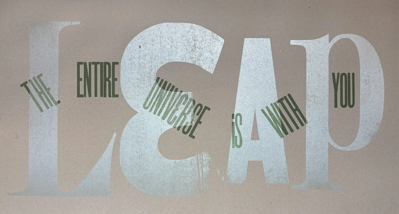 Inspirational quote on a wall that reads, 'The ENTIRE canvas is yours to create with,' with large, light blue and green text on a beige background.