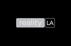 The words "reality" and "LA" in a stylized logo with gray and black color scheme