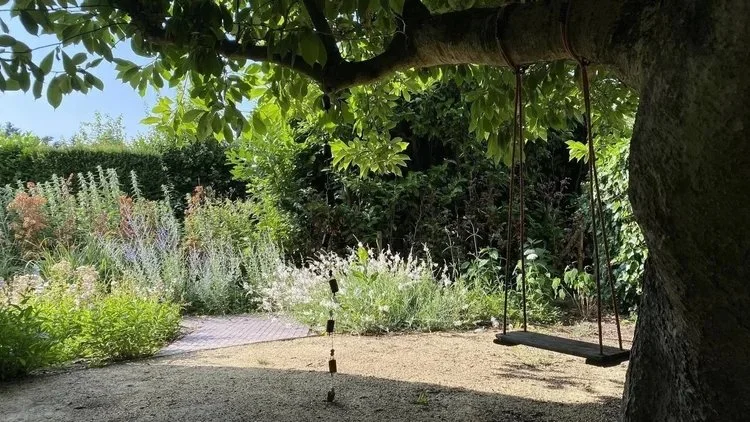 de-tuinen-van-tom-struyf-romantische-tuin-bloementuin-beplanting-grind-schommel-boom-schaduw.jpeg