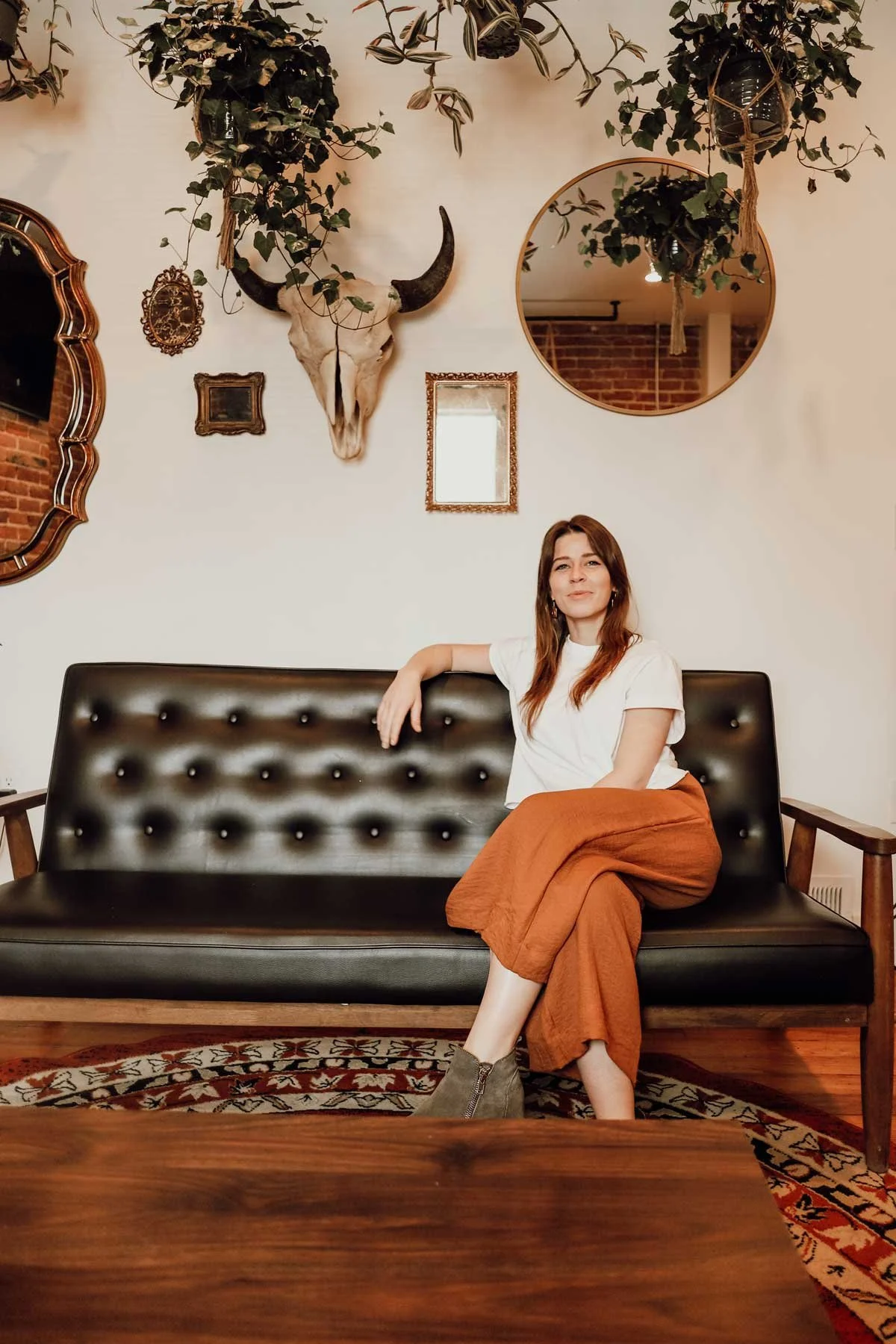 Erin sitting on a couch at The Mindful Bird in Denver, fully embodied in her authentic self
