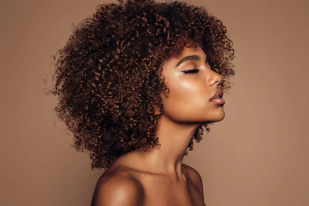 Close portrait of a client with curly hair and softly defined natural brows