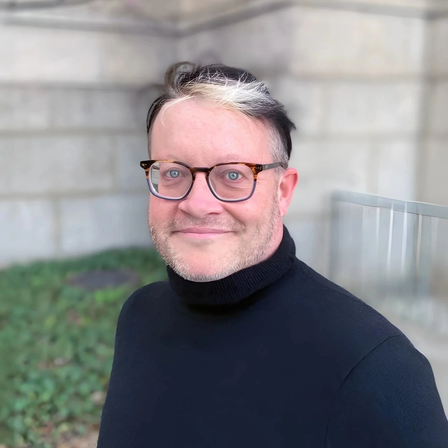 Gender affirming therapist in dc wearing glasses and black turtleneck