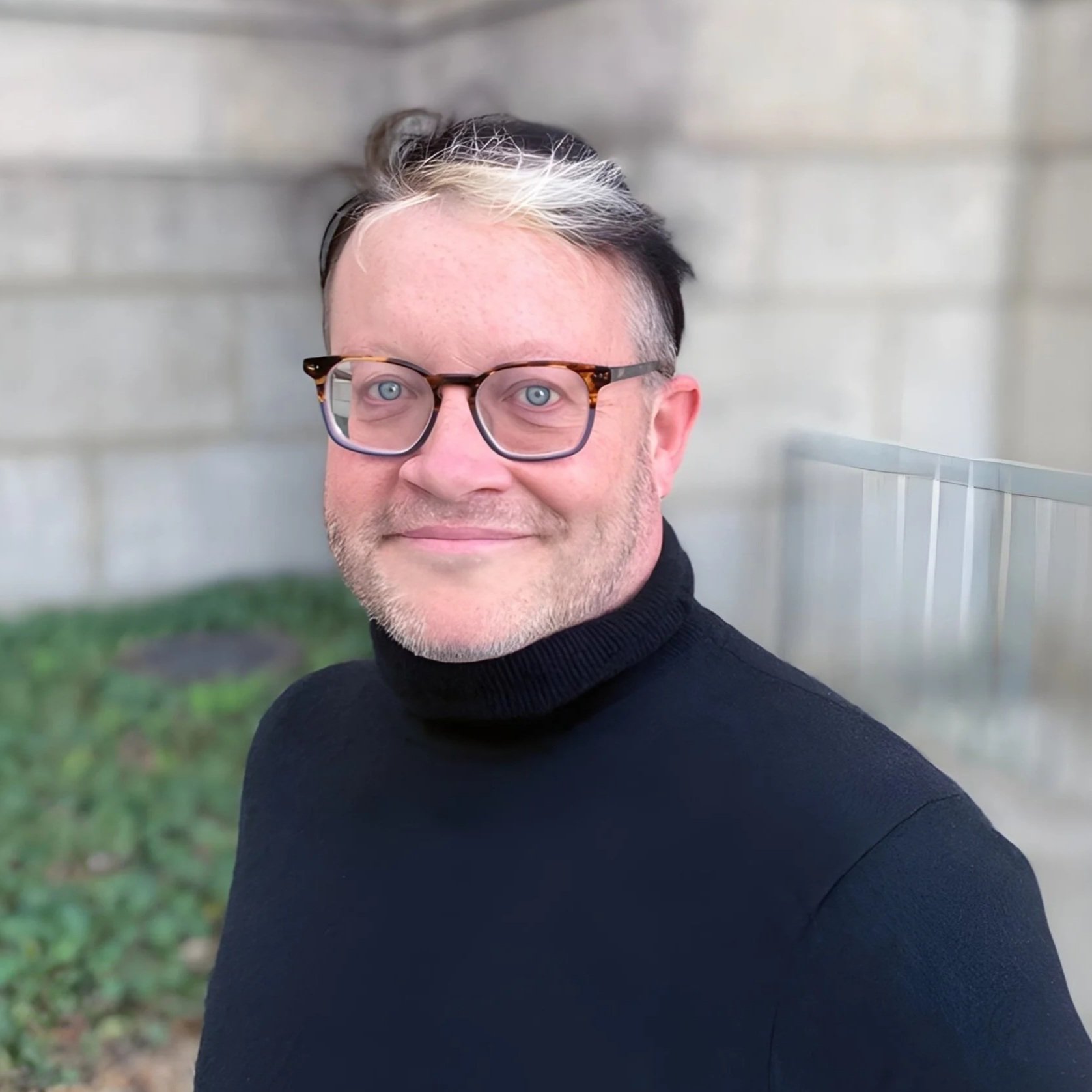 Gender affirming therapist in dc wearing glasses and black turtleneck