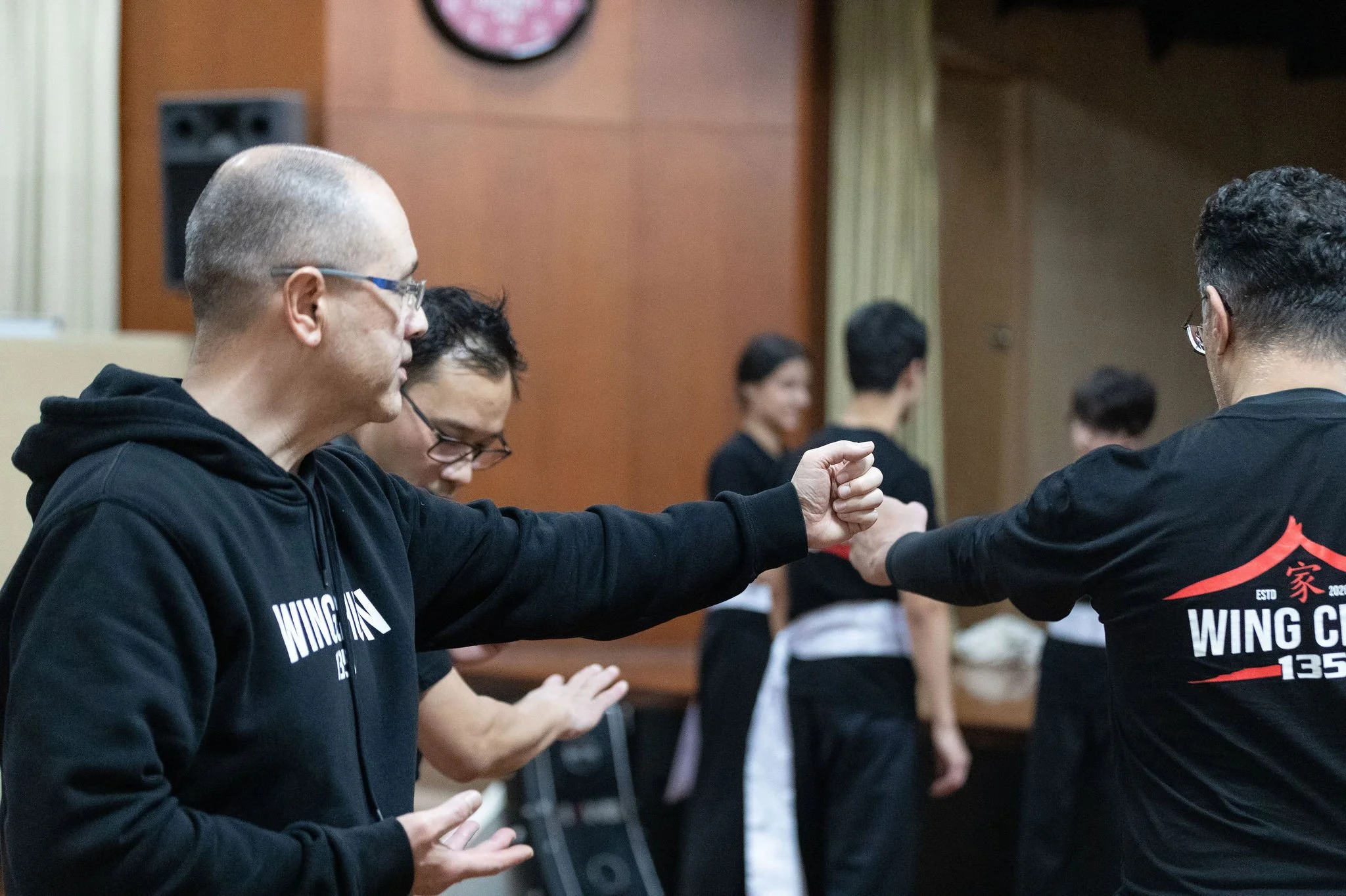 A group of people participating in a martial arts or self-defense class at 32 showground rd , castle hill, practicing techniques with partners.
