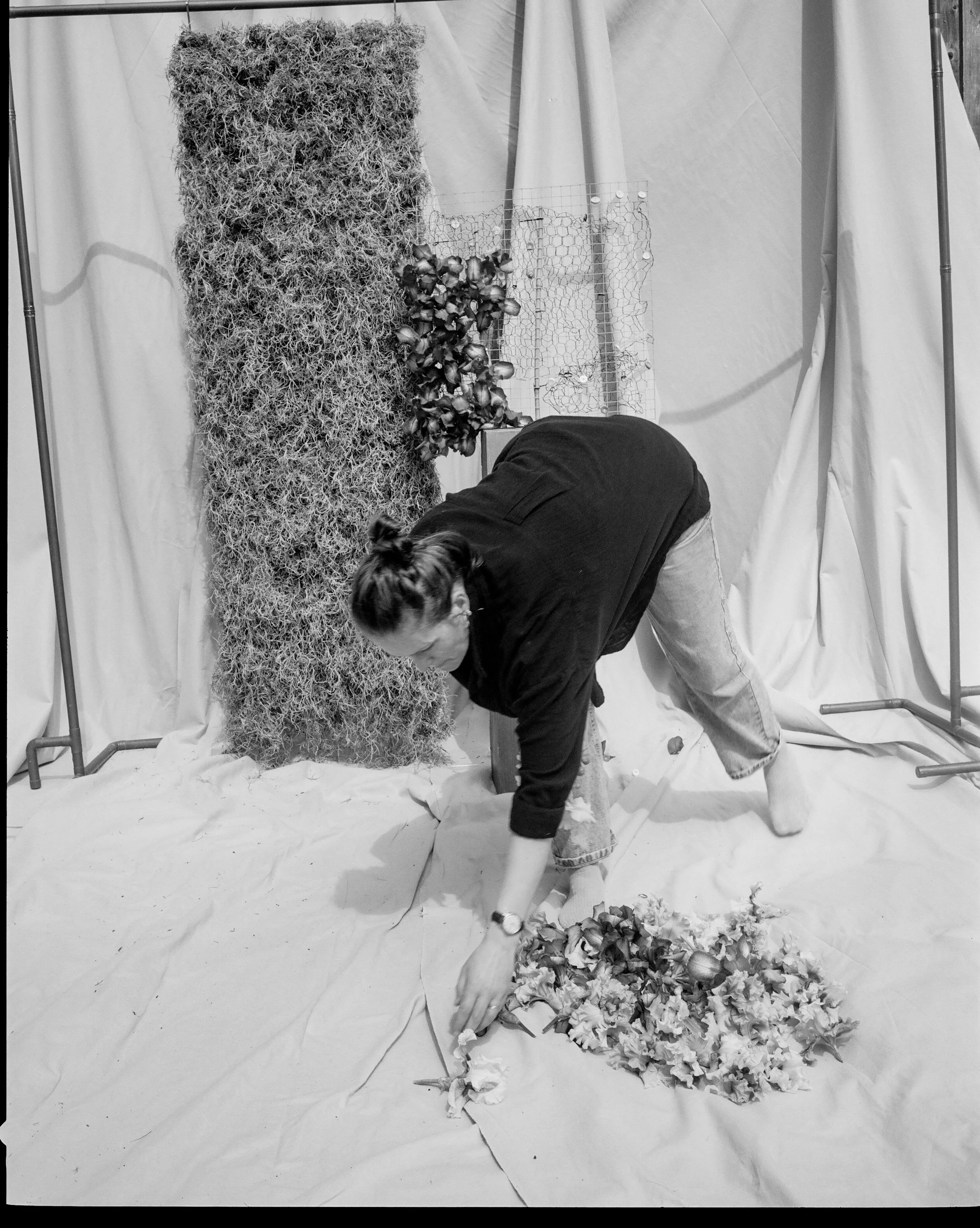 Rachel Grimes florist working on Iris and moss installation with fabric backdrop summer